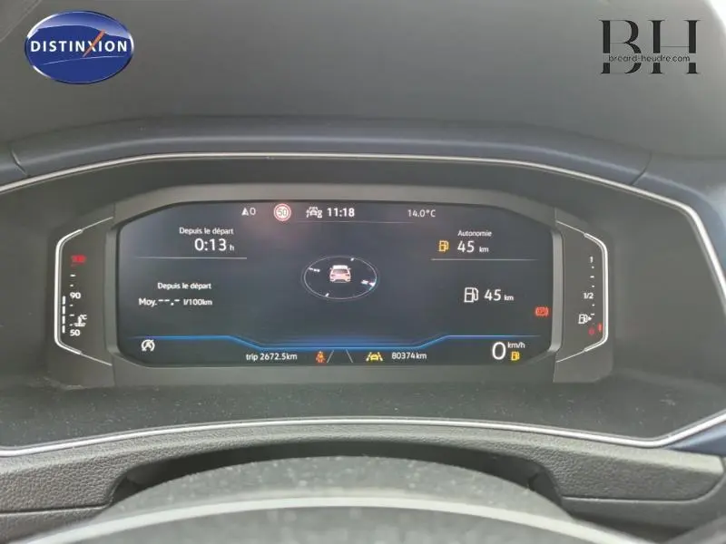 Tableau de bord numérique du Volkswagen T-ROC gris 2021 affichant autonomie, vitesse et température extérieure.