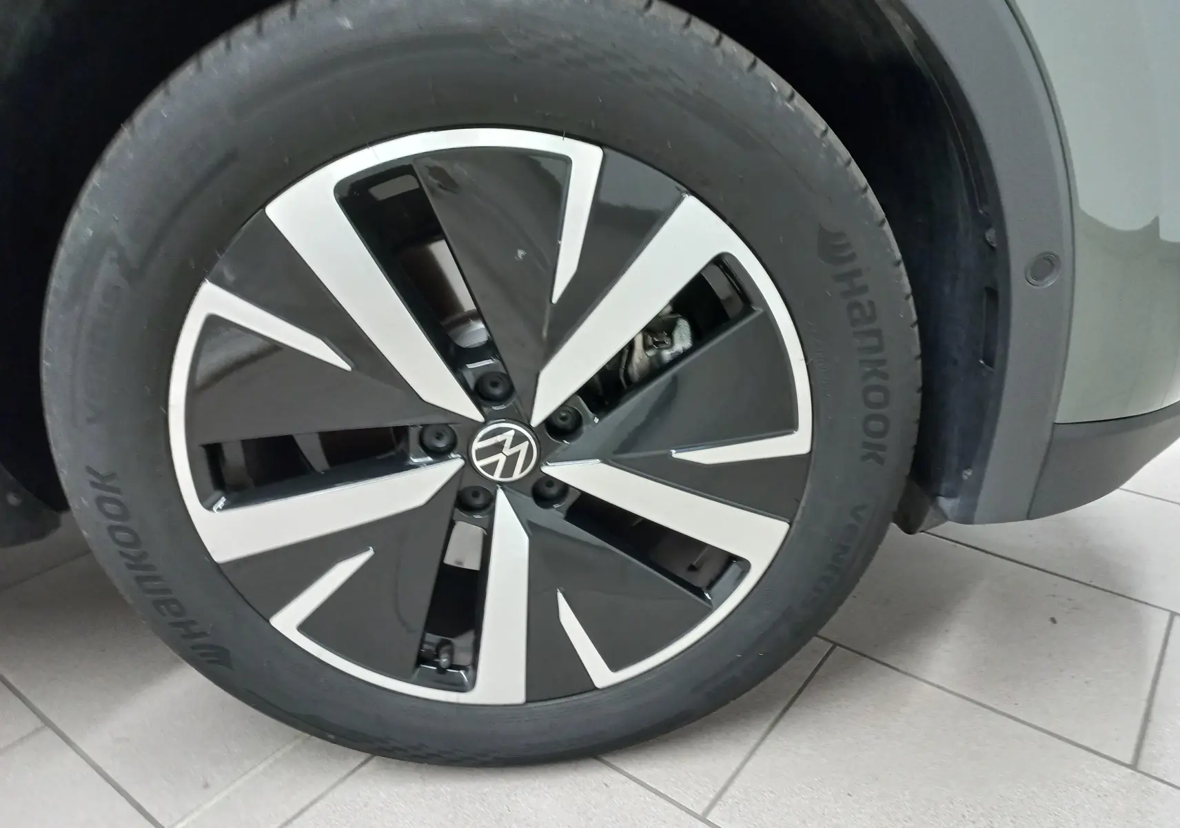 Gros plan sur la jante en alliage noir et argent "Catania" de 19 pouces du Volkswagen Tiguan Vert Cipressino 2025.