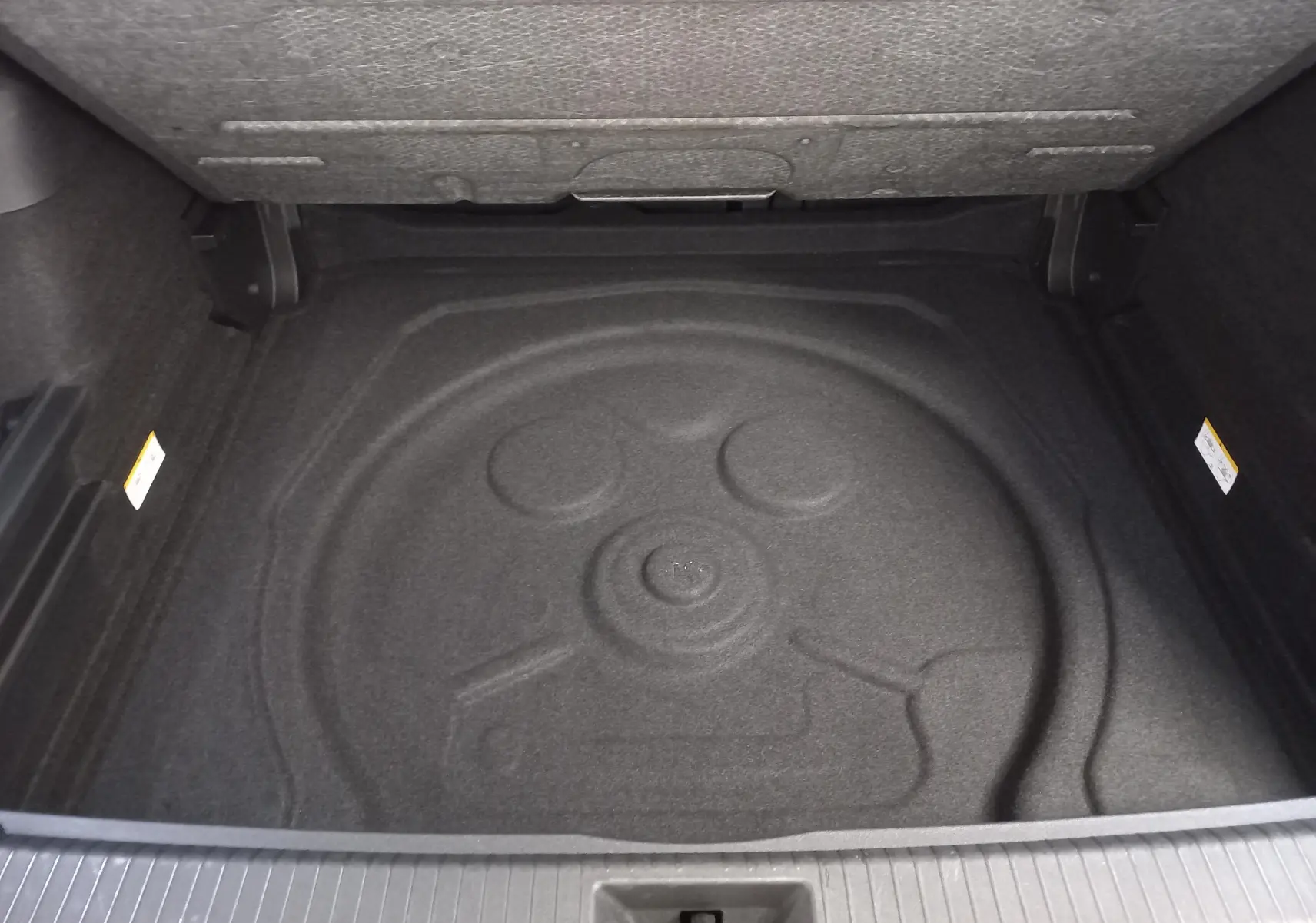 Coffre ouvert du Volkswagen Tiguan 2.0 TDI 150 DSG7 VW Edition 2025, vue intérieure sans roue de secours visible.