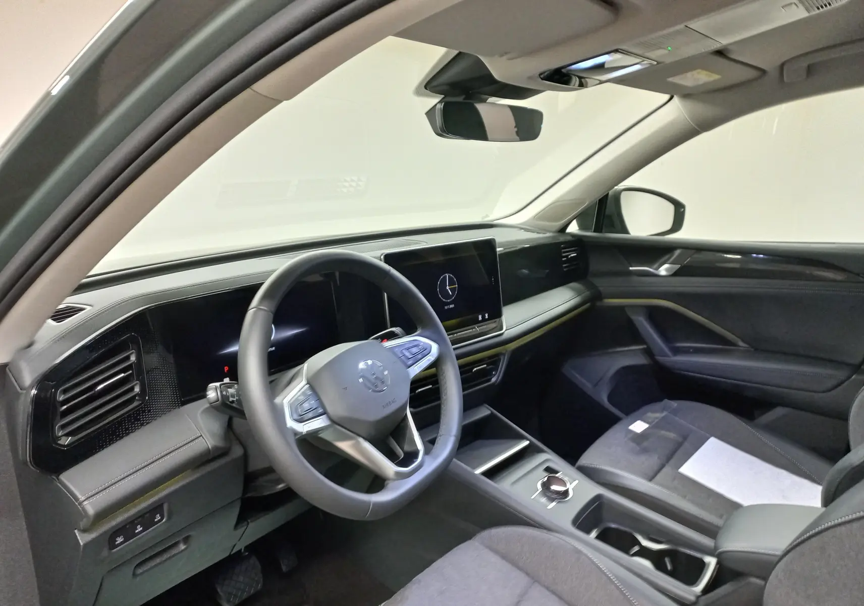 Intérieur moderne du Volkswagen Tiguan 2025, vue côté conducteur montrant le tableau de bord et l'écran tactile central.