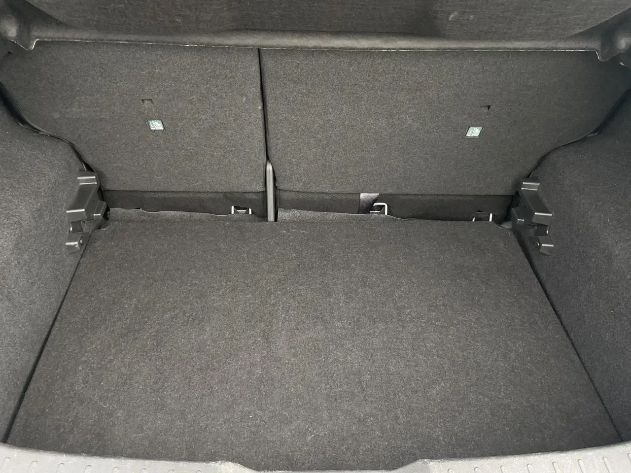 Coffre vide en vue plongeante du Nissan Juke 2024 gris Silver, montrant l'espace de chargement et le revêtement intérieur.