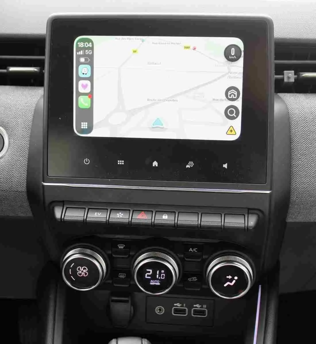 Gros plan sur l’écran tactile central et les commandes de climatisation de la Renault Clio noire étoile métal 2025.