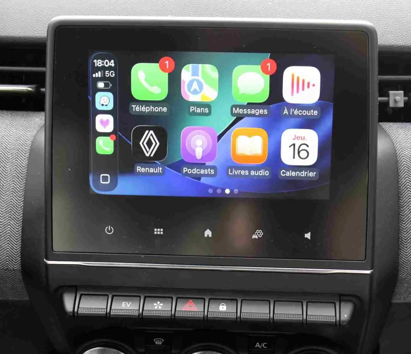 Écran tactile central de la Renault Clio 2025 affichant l'interface Apple CarPlay avec icônes colorées.