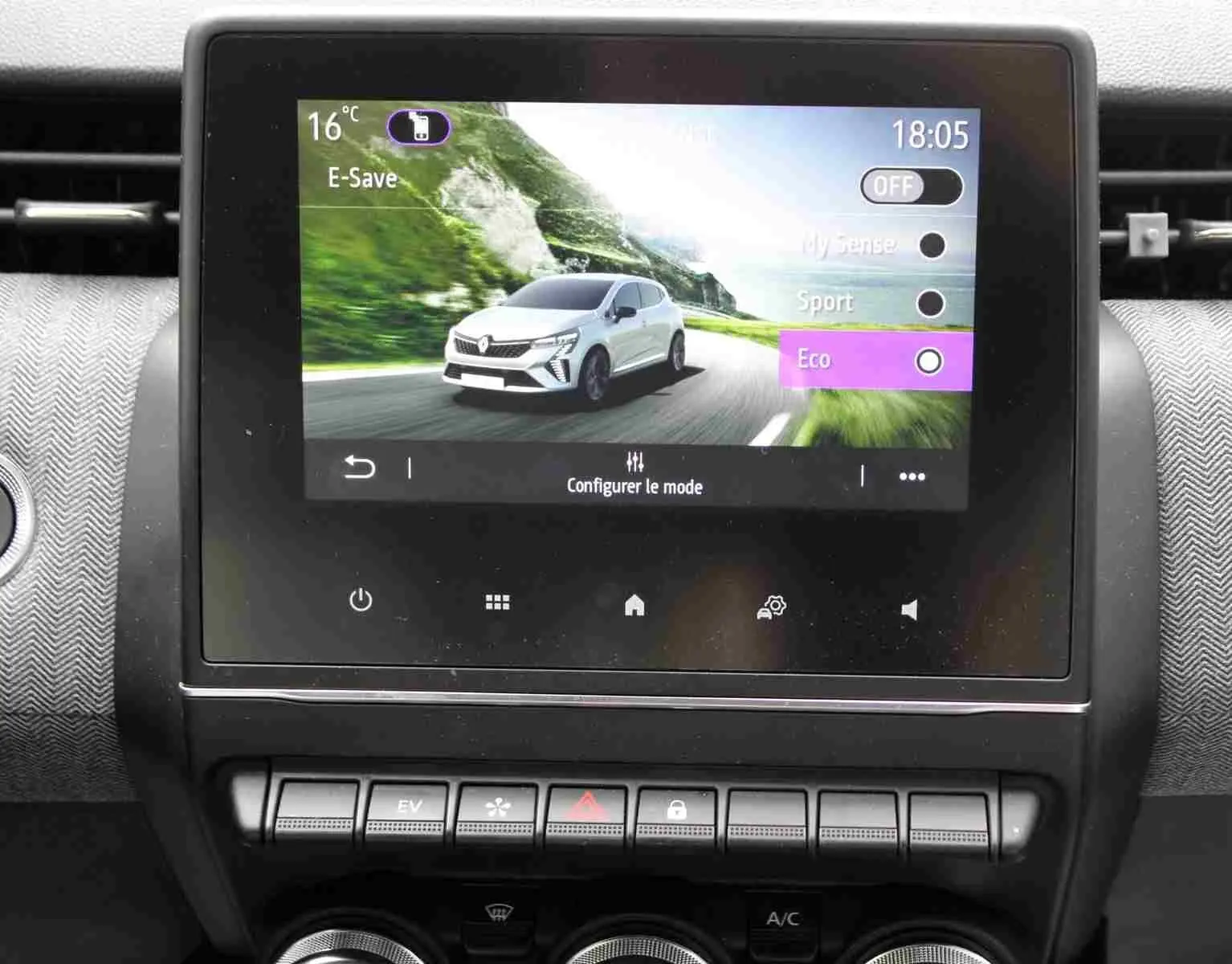 Écran tactile central affichant une Renault Clio blanche en mode Eco sur route de montagne, intérieur noir étoile métal.