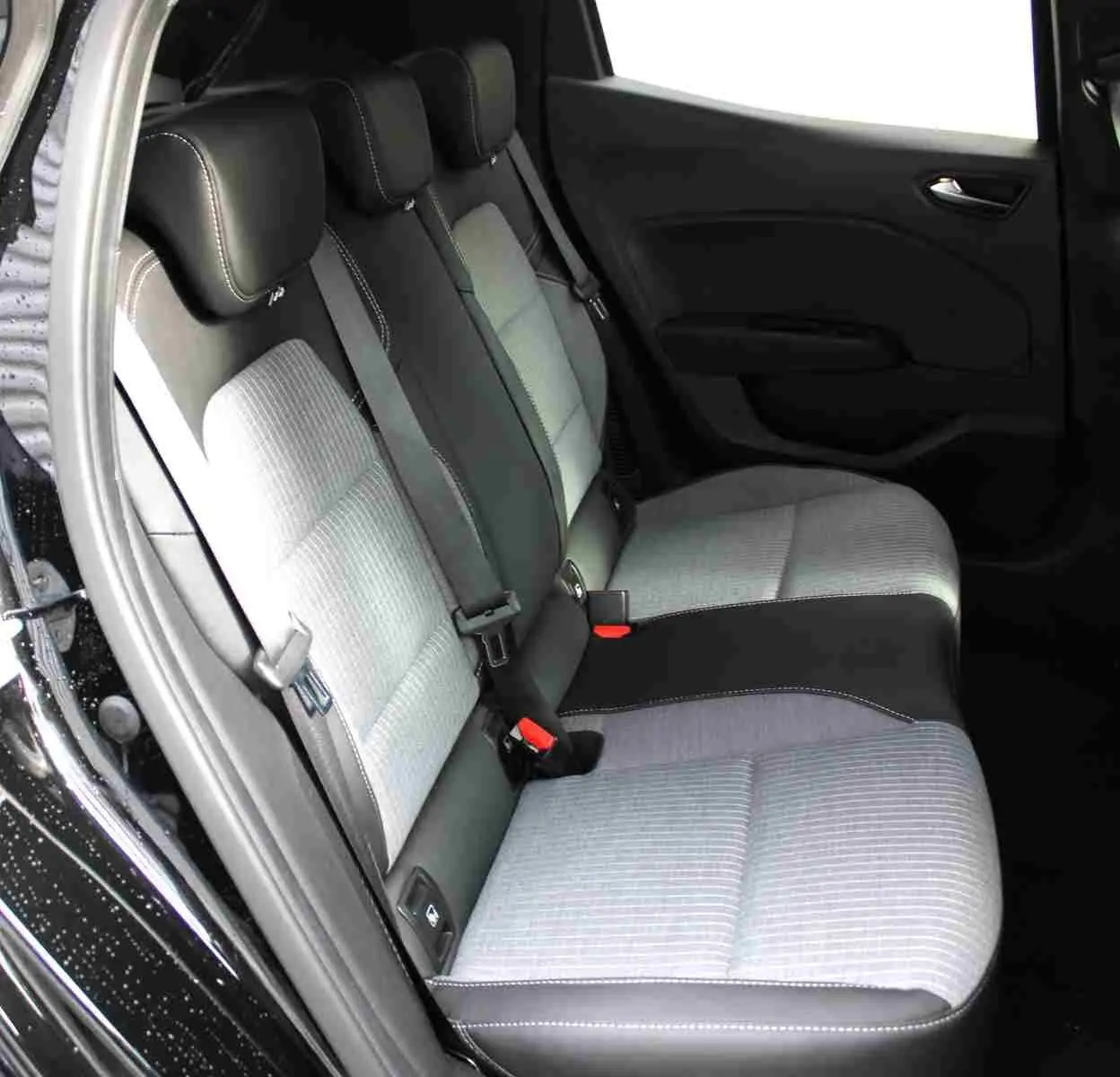 Vue intérieure côté gauche des sièges arrière gris clair et noir de la Renault Clio 2025, porte ouverte.