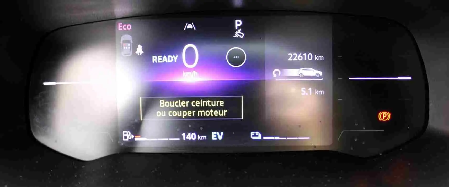 Affichage numérique du tableau de bord de la Renault Clio hybride, indiquant 0 km/h et un rappel de boucler la ceinture.