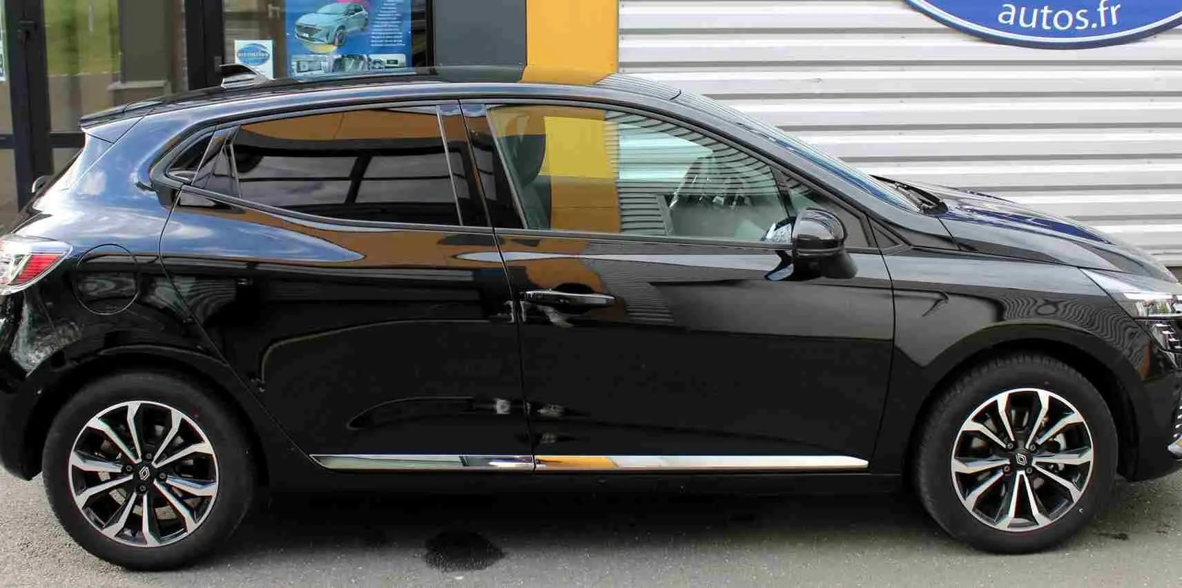 Profil côté gauche de la Renault Clio 2025 noire étoile métal avec jantes alliage bicolores et vitres teintées.