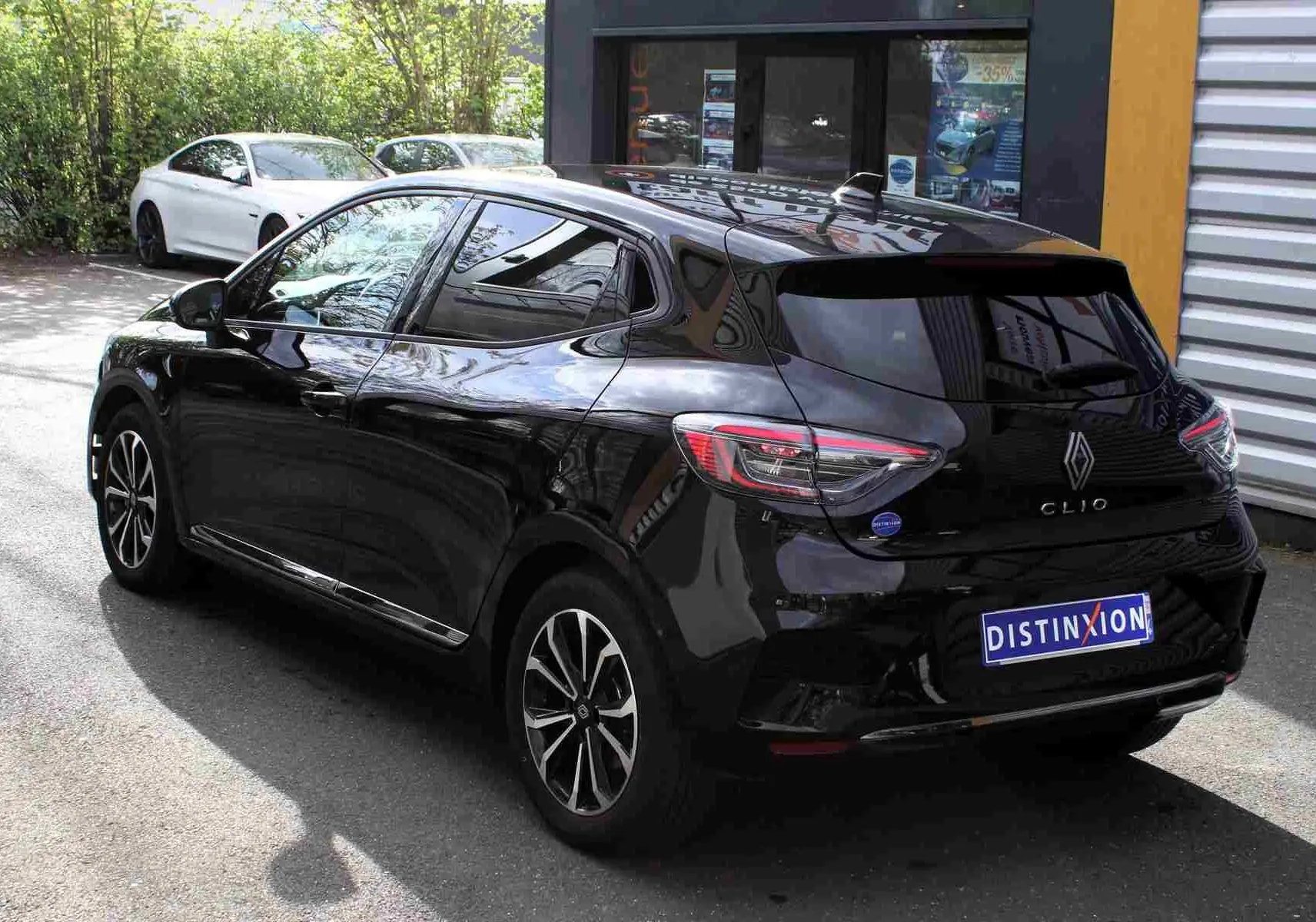 Vue 3/4 arrière droite d'une Renault Clio noire étoile métal avec feux LED et jantes bi-ton.