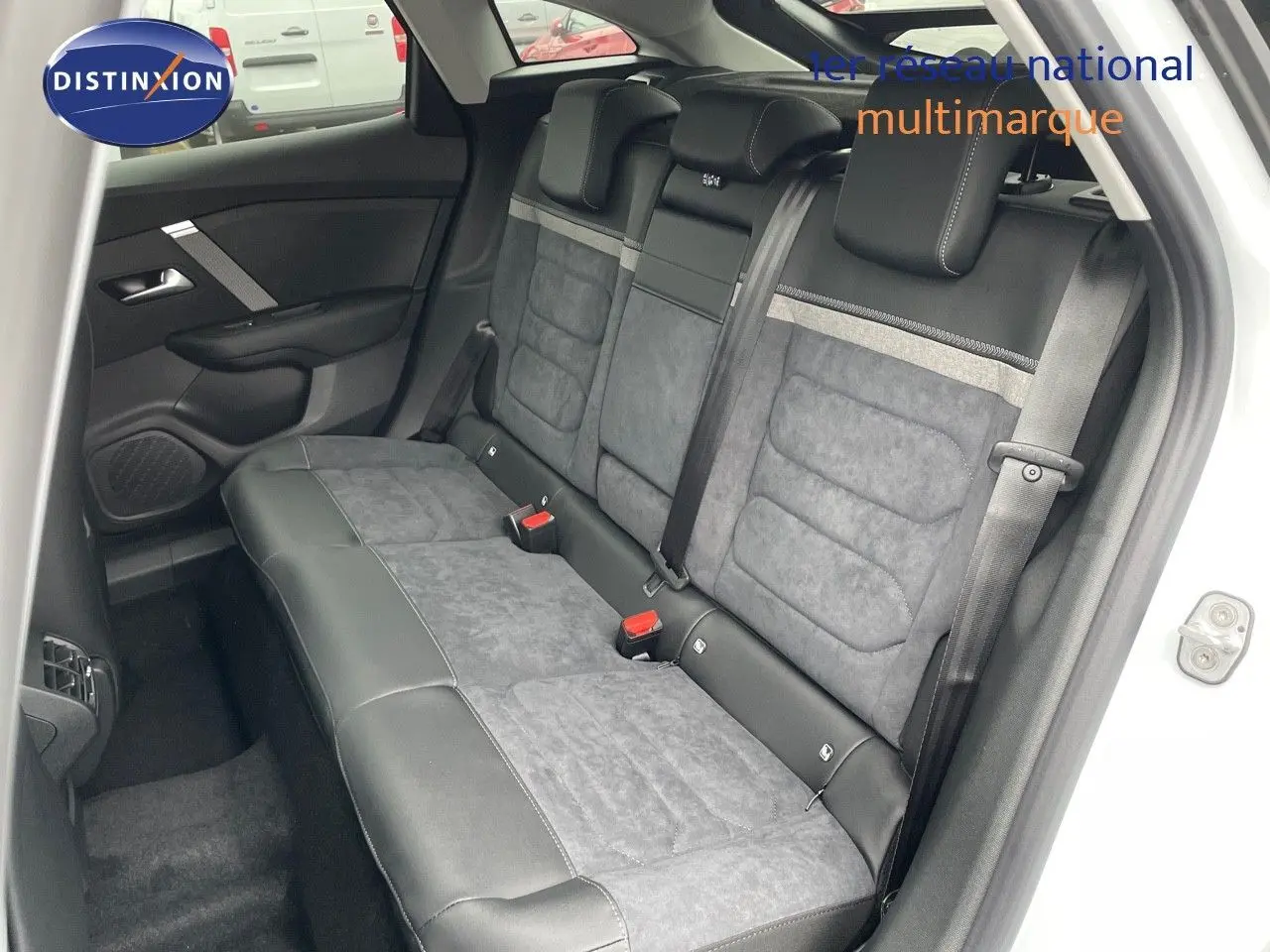 Banquette arrière en cuir noir et tissu gris de la Citroën C4 blanche, vue côté gauche avec ceinture de sécurité visible.