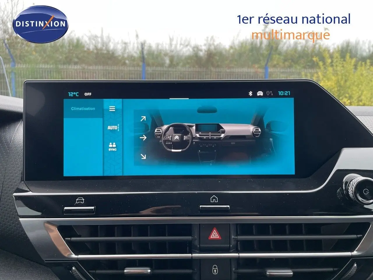 Écran tactile du tableau de bord de la Citroën C4 blanche, affichant les commandes de climatisation et la vue intérieure.