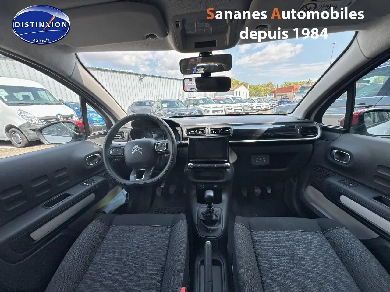 Vue intérieure avant de la Citroën C3 2023 avec tableau de bord noir et volant multifonction.