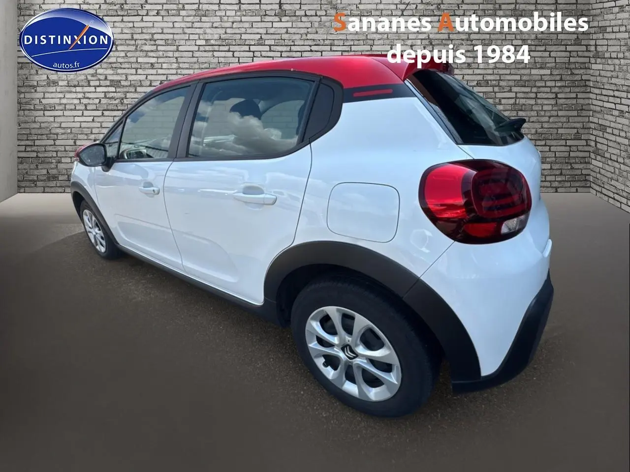 Citroën C3 2023 blanc banquise avec toit rouge, vue 3/4 arrière côté gauche, élargisseurs d'ailes noirs mats visibles.