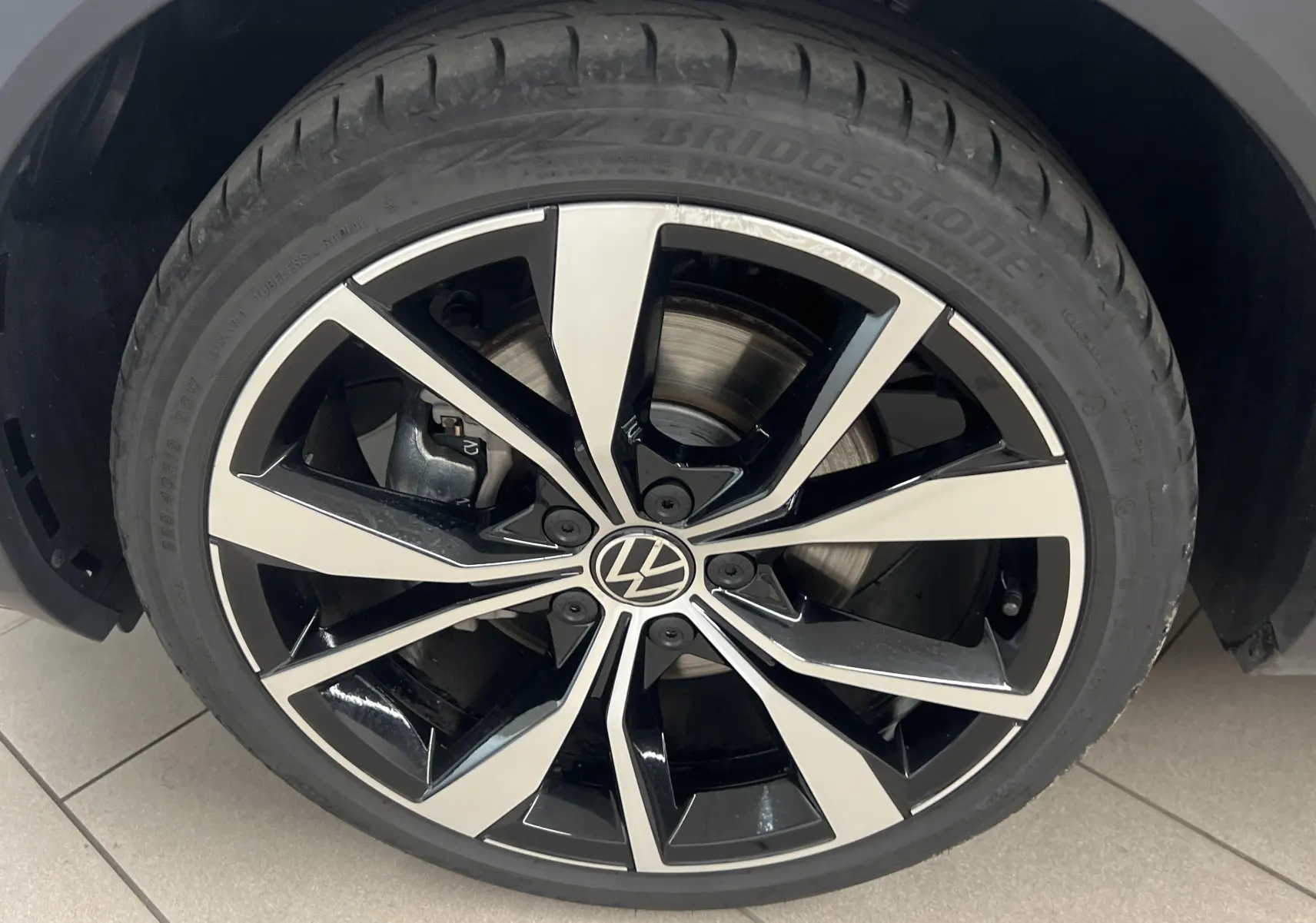 Gros plan sur la jante 19 pouces Misano bicolore noir et argent du Volkswagen T-Roc Gris Pyrite 2024.