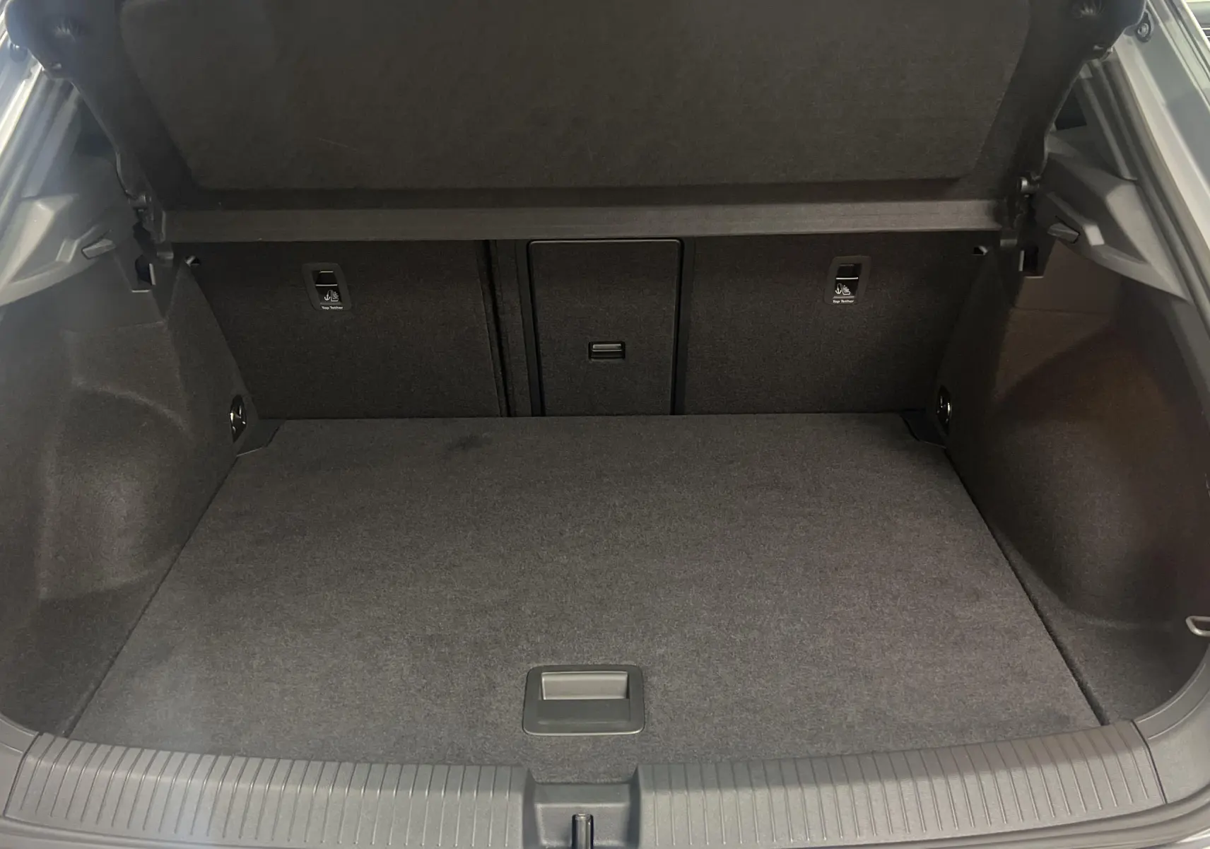 Coffre ouvert du Volkswagen T-Roc gris pyrite, montrant l'espace de chargement intérieur propre et spacieux.