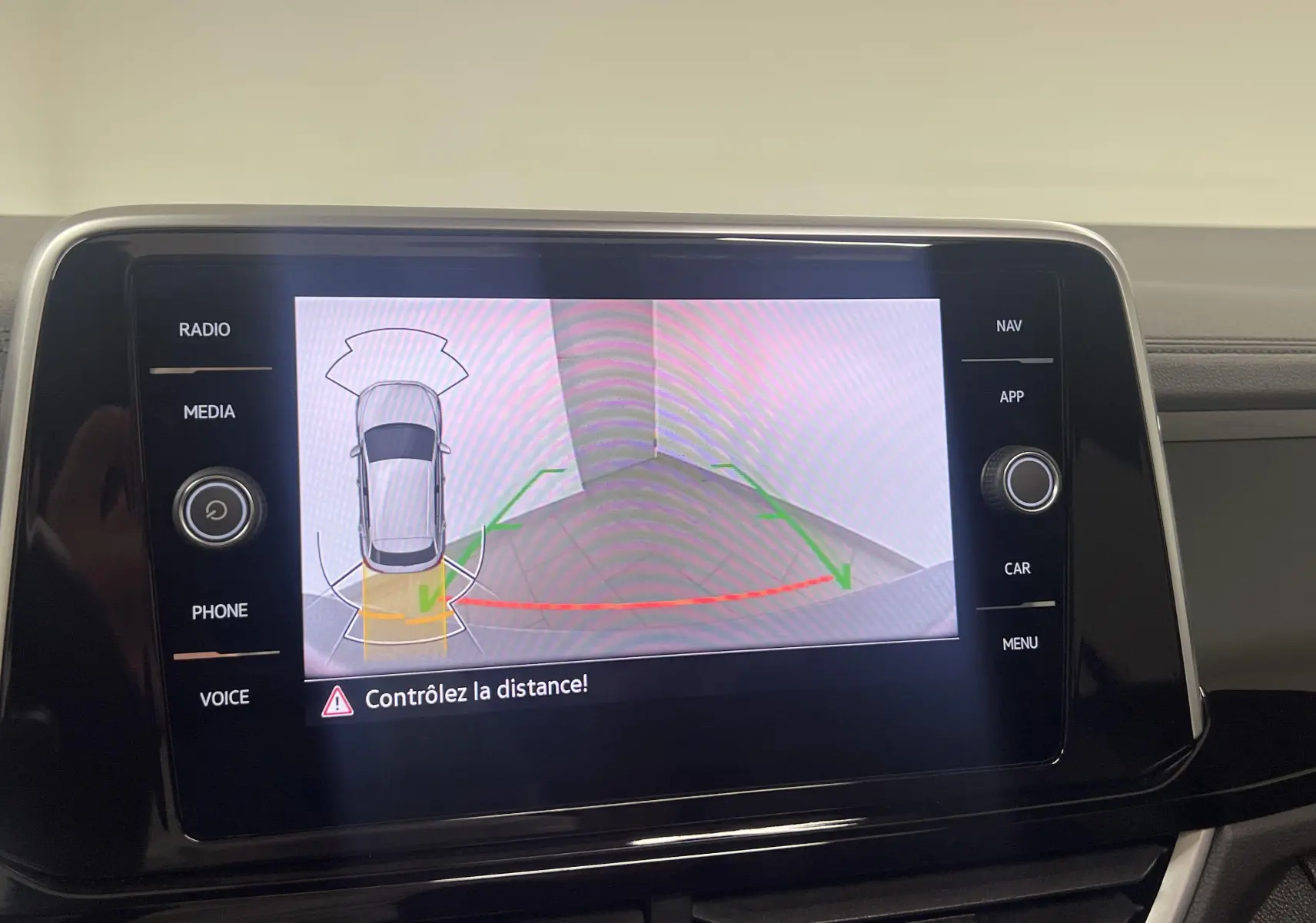 Écran central du Volkswagen T-Roc 2024 montrant l'aide au stationnement avec vue caméra arrière et alertes de distance.