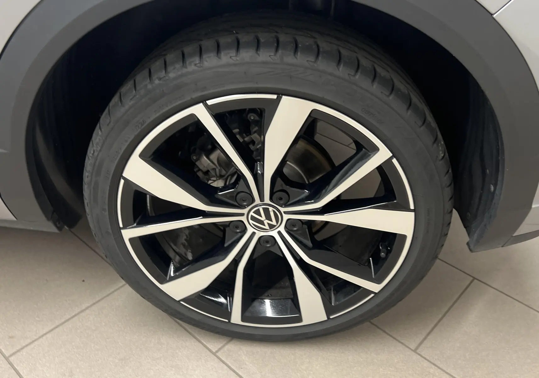 Gros plan sur la jante 19 pouces Misano bicolore noir et argent du Volkswagen T-Roc gris pyrite.