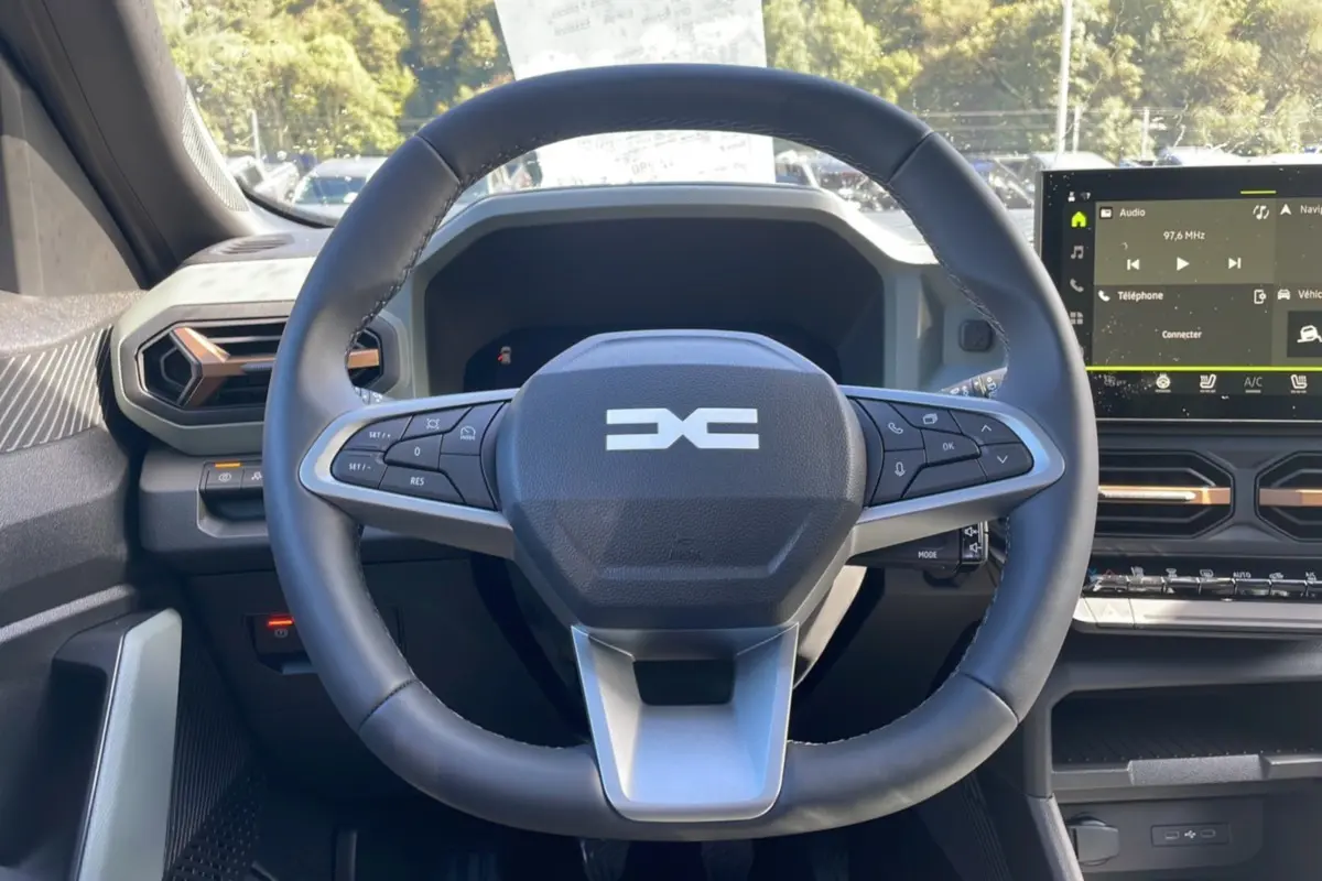 Vue intérieure centrée sur le volant cuir du Dacia Bigster TCE 130 4x4 Extreme Plus avec tableau de bord digital.