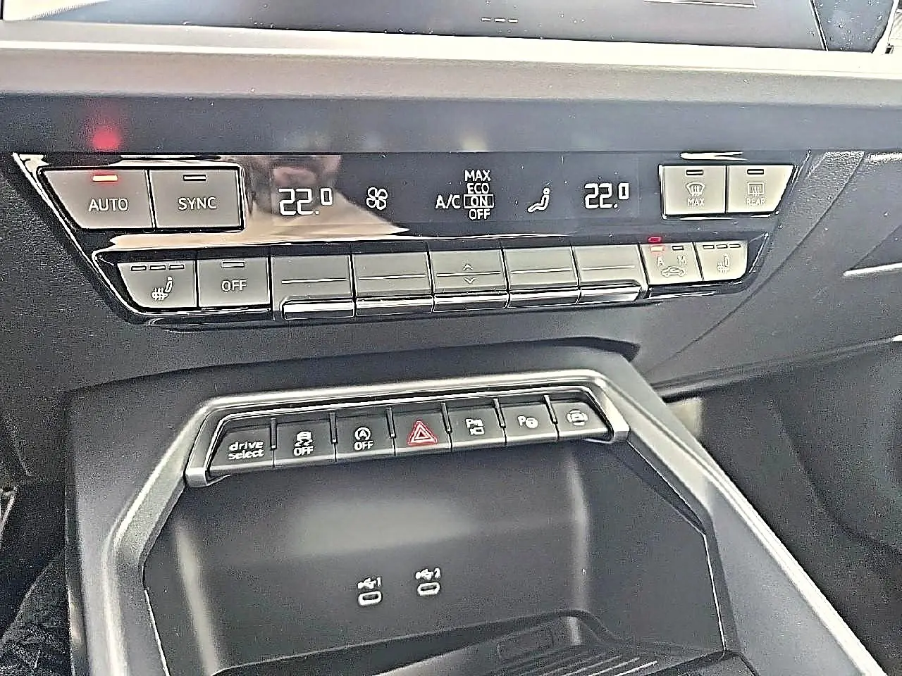 Vue rapprochée de la console centrale noire avec commandes climatisation et boutons multifonctions de l'Audi A3 Sportback 2026.