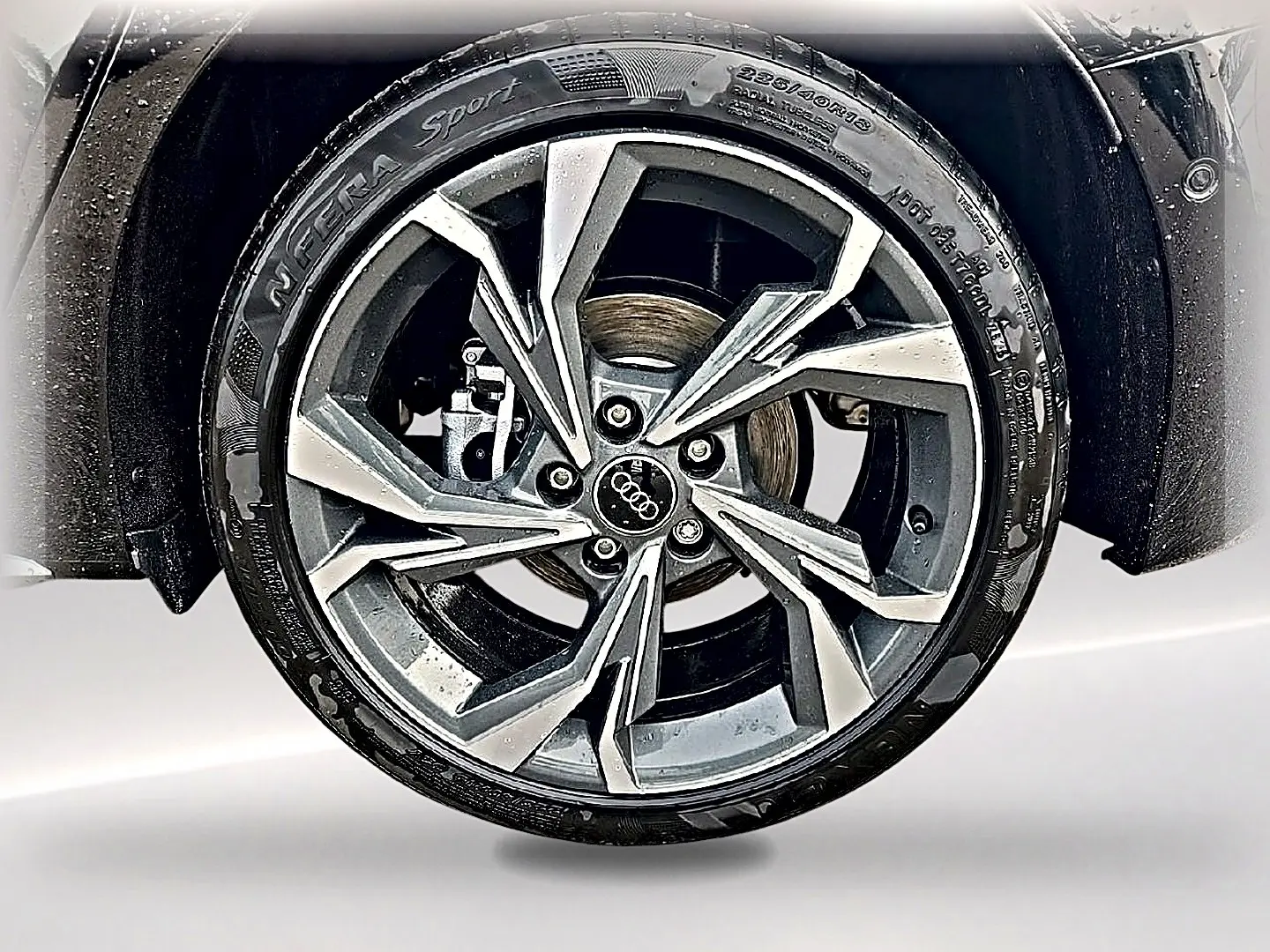 Gros plan sur la jante alu gris graphite à design sportif de l'Audi A3 Sportback noir Mythos.