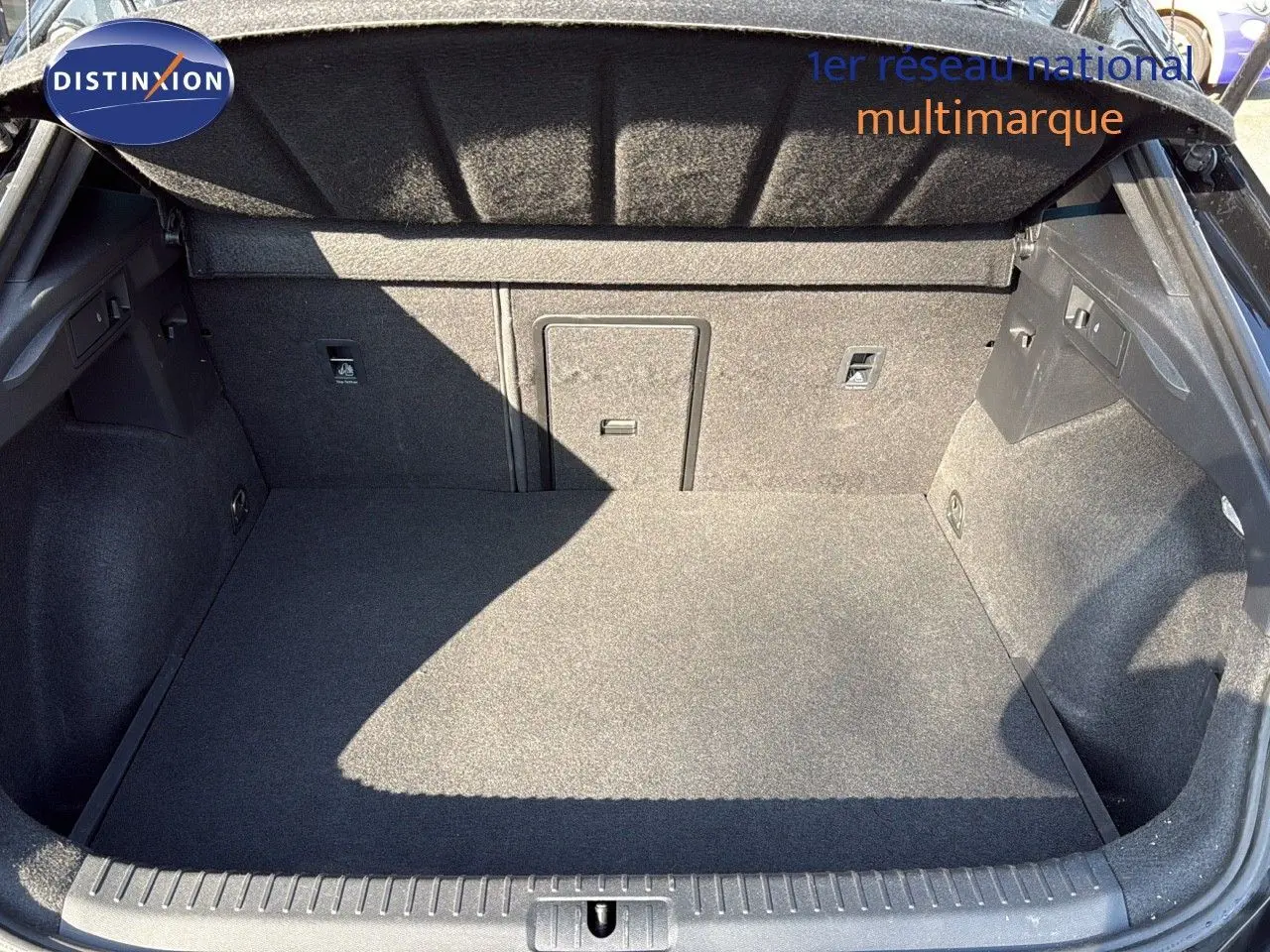 Coffre ouvert vu de face d’un CUPRA Formentor noir minuit métal, montrant un espace de chargement propre et spacieux.