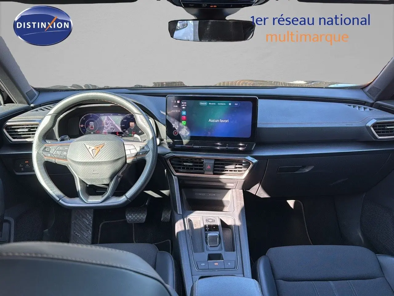 Vue intérieure avant du CUPRA Formentor 1.4 E-HYBRID 2023, tableau de bord noir avec écran tactile central et volant multifonction.