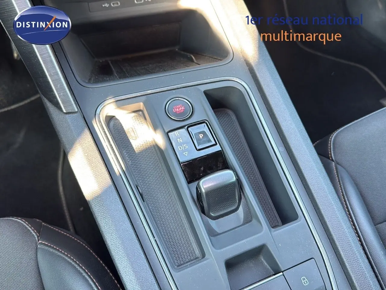 Vue rapprochée de la console centrale noire du CUPRA Formentor 1.4 E-HYBRID avec sélecteur de boîte automatique et bouton start/stop.