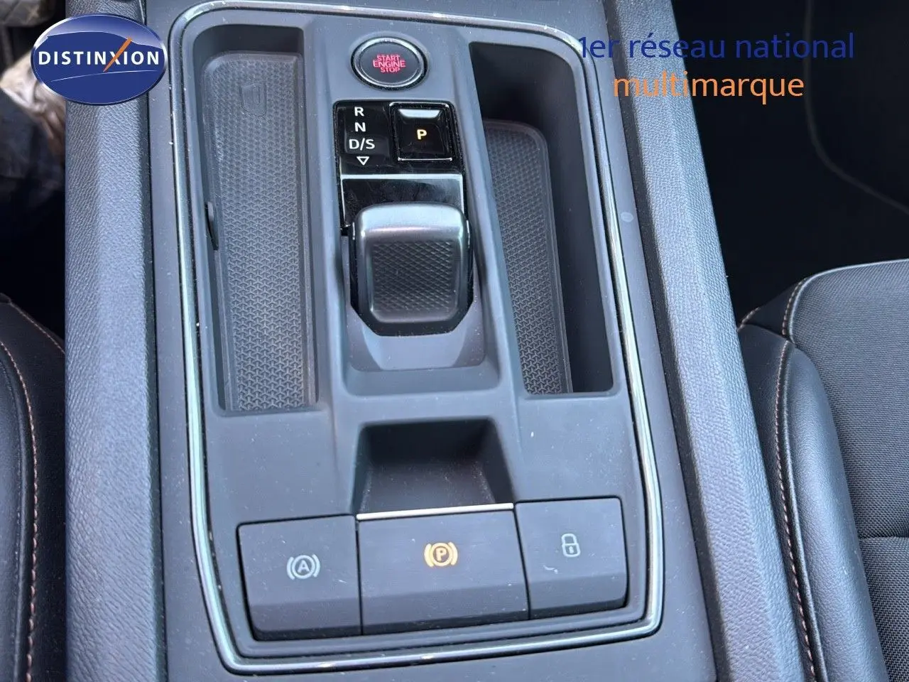 Vue rapprochée de la console centrale noire du CUPRA Formentor 1.4 E-HYBRID avec sélecteur de boîte automatique et boutons de contrôle.