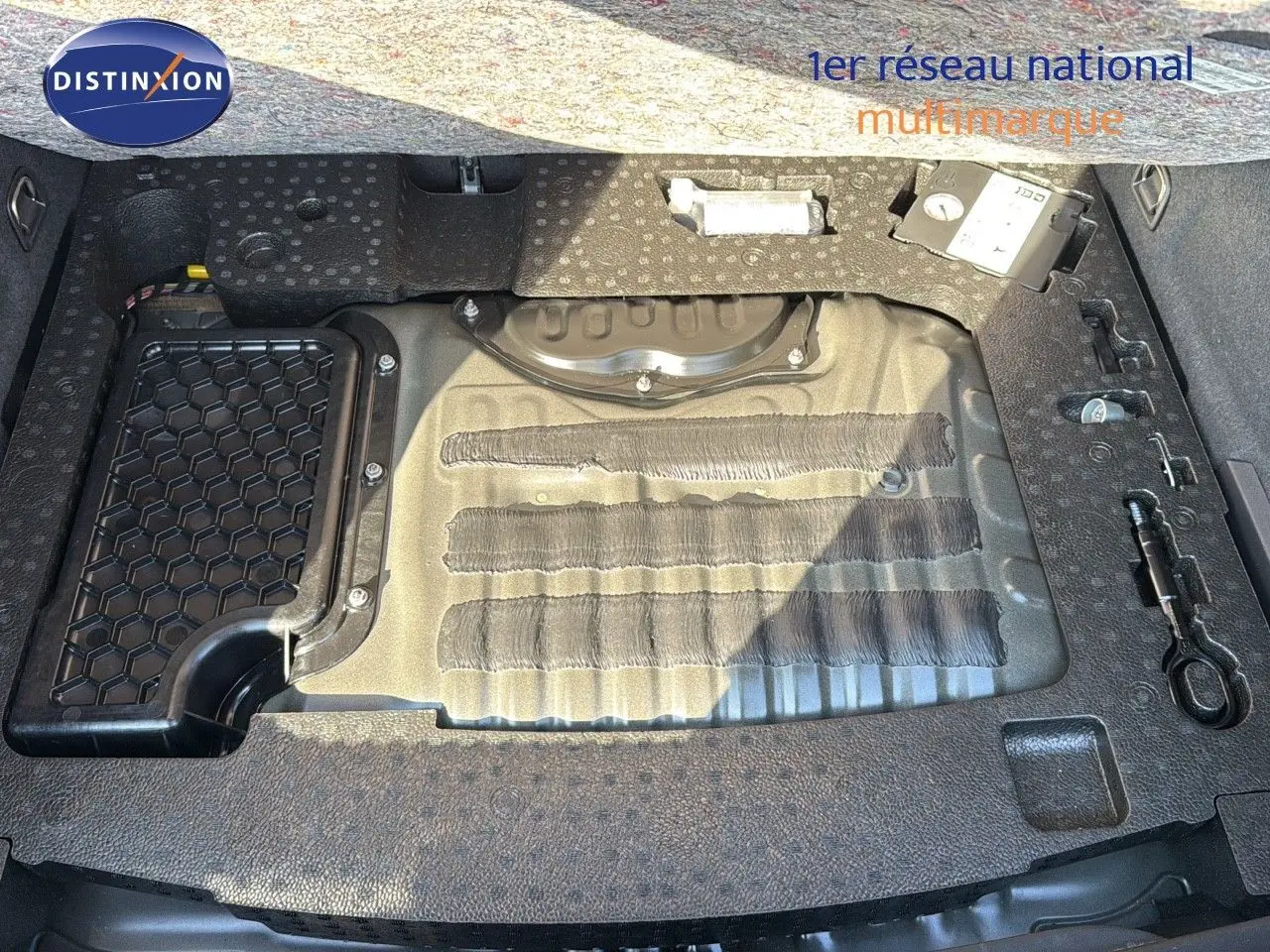 Coffre ouvert montrant le compartiment de rangement sous plancher du CUPRA Formentor noir minuit, avec outils intégrés.