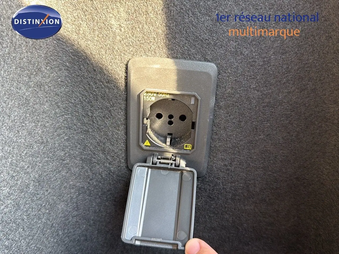 Prise de recharge hybride ouverte dans le coffre d’un CUPRA Formentor noir minuit, vue rapprochée.