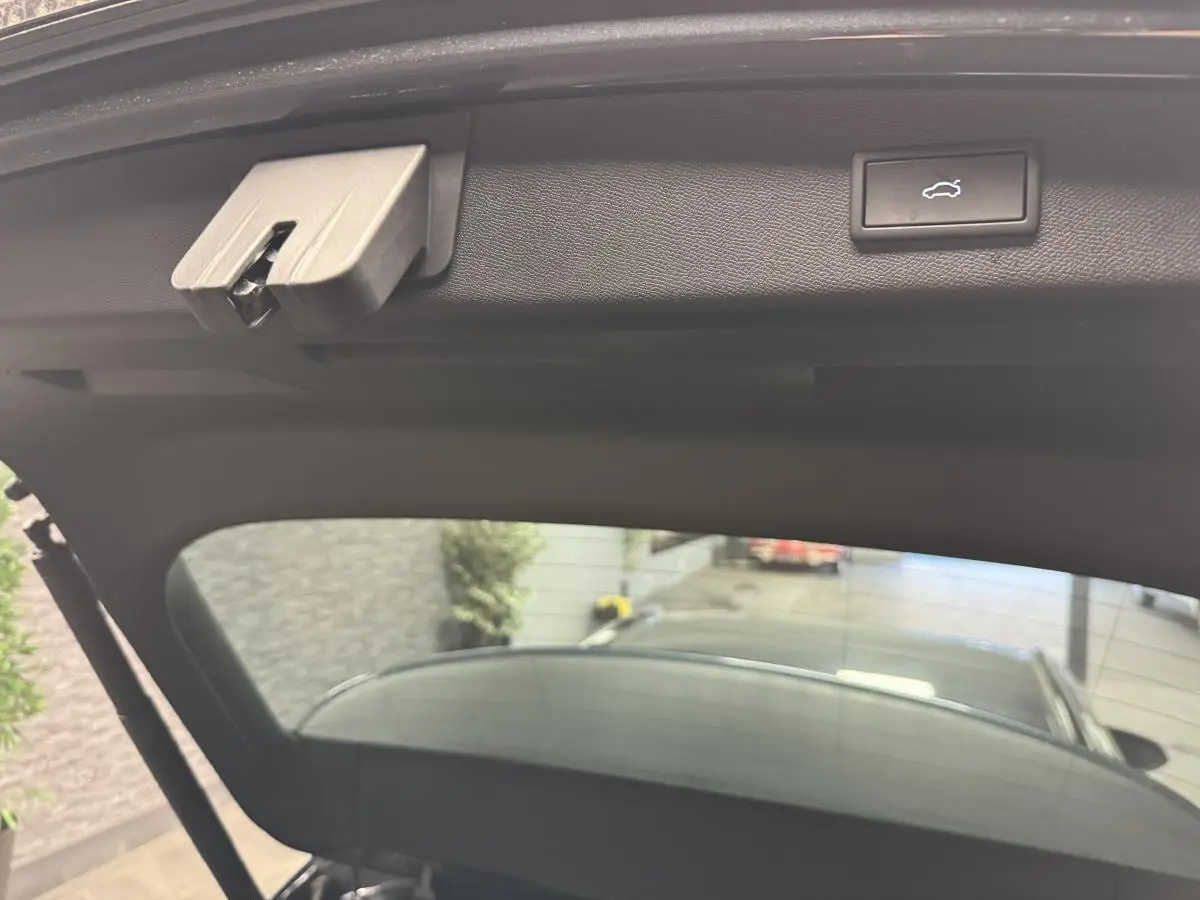 Vue intérieure du hayon ouvert de la CUPRA Leon Sportstourer gris, montrant le bouton d'ouverture électrique.