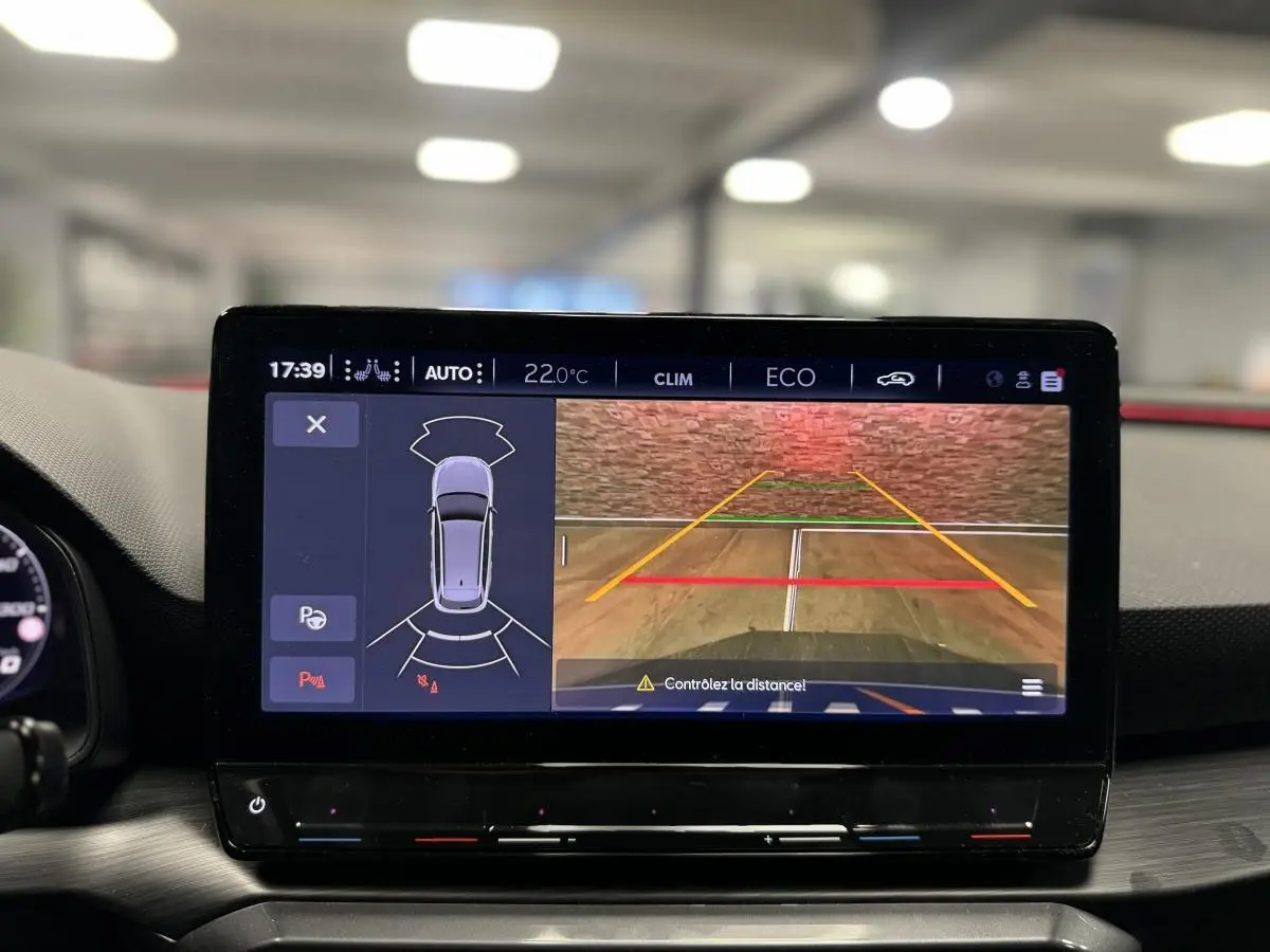 Écran tactile intérieur affichant la caméra de recul et l'aide au stationnement du CUPRA Leon Sportstourer gris 2024.