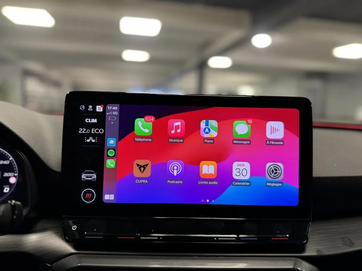 Écran tactile central affichant l'interface Apple CarPlay dans l'habitacle d'une CUPRA Leon Sportstourer 2024.