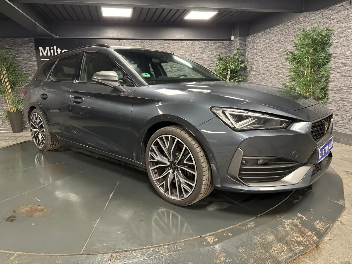 Vue 3/4 avant droit d'une CUPRA Leon Sportstourer 2024 gris magnétique avec jantes alliage 19 pouces Palm Springs.