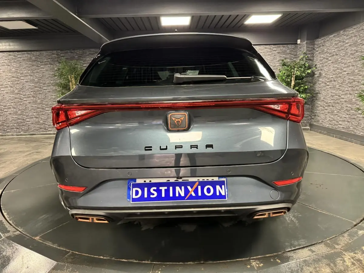 Vue arrière d'une CUPRA Leon Sportstourer gris magnétique avec feux LED et double sortie d'échappement cuivrée.