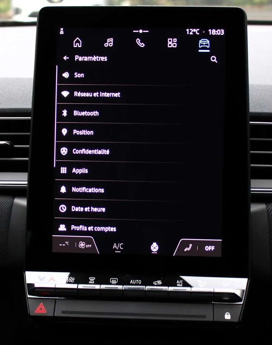 Écran tactile central du tableau de bord du Renault Captur 2025 avec menu paramètres et commandes climatisation.
