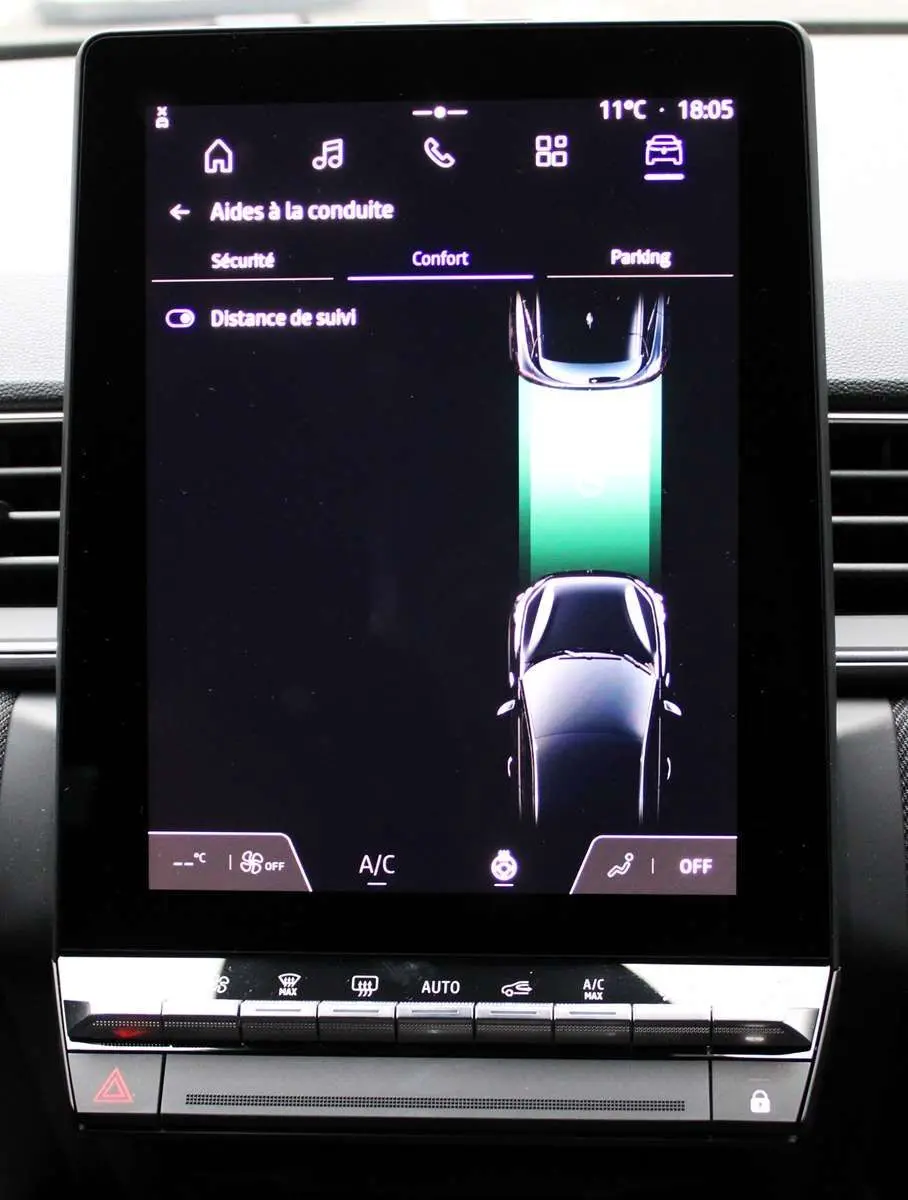 Écran tactile central du Renault Captur 2025 montrant l'aide à la conduite avec vue du véhicule en noir sur fond sombre.
