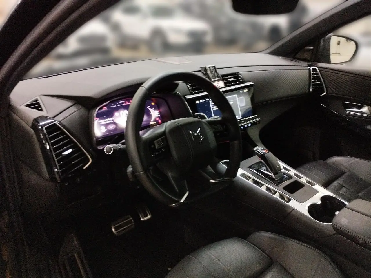 Vue intérieure côté conducteur du DS7 2025 noir Perla, montrant le tableau de bord numérique et la console centrale moderne.