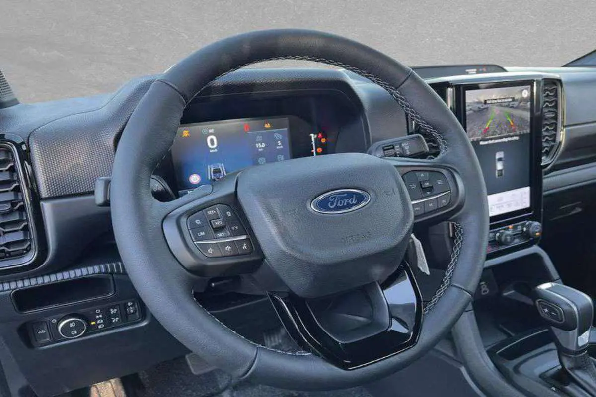 Vue rapprochée du volant cuir multifonctions et du tableau de bord numérique du Ford Ranger 2025.