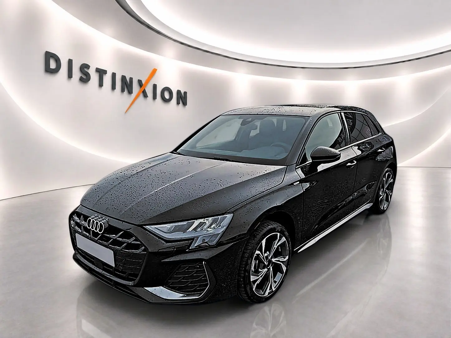 Audi A3 Sportback noir mythos vue 3/4 avant droit avec jantes alu et calandre S line dans showroom lumineux.