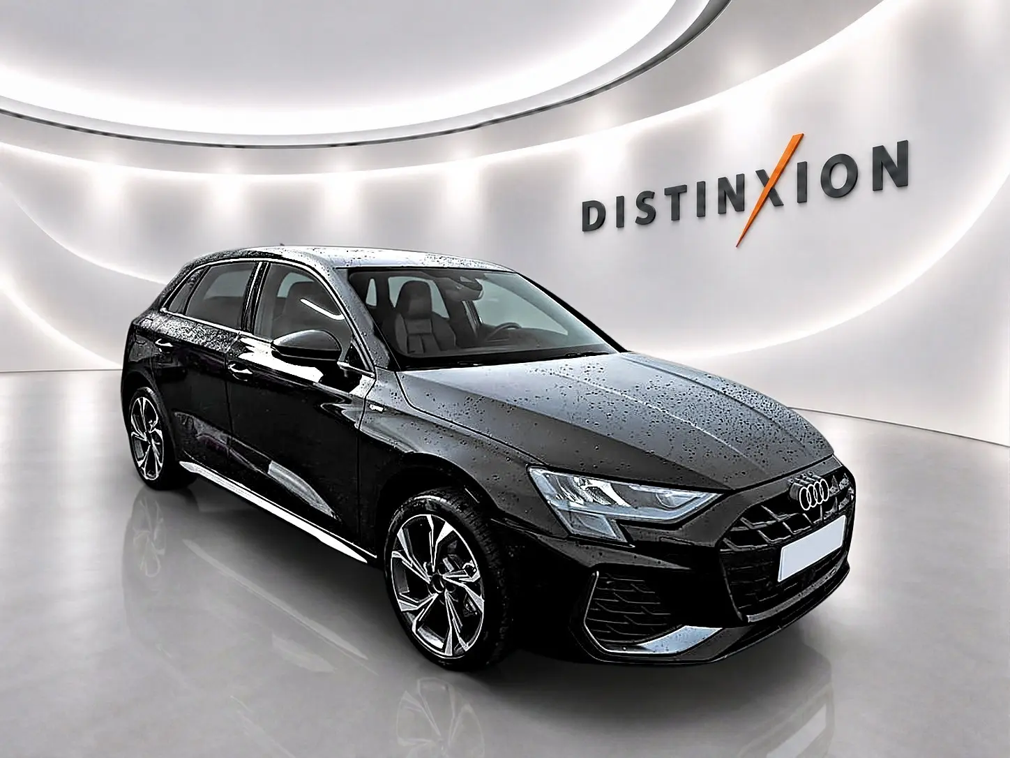 Audi A3 Sportback noir mythos vue 3/4 avant droit avec jantes alu et phares LED dans un showroom lumineux