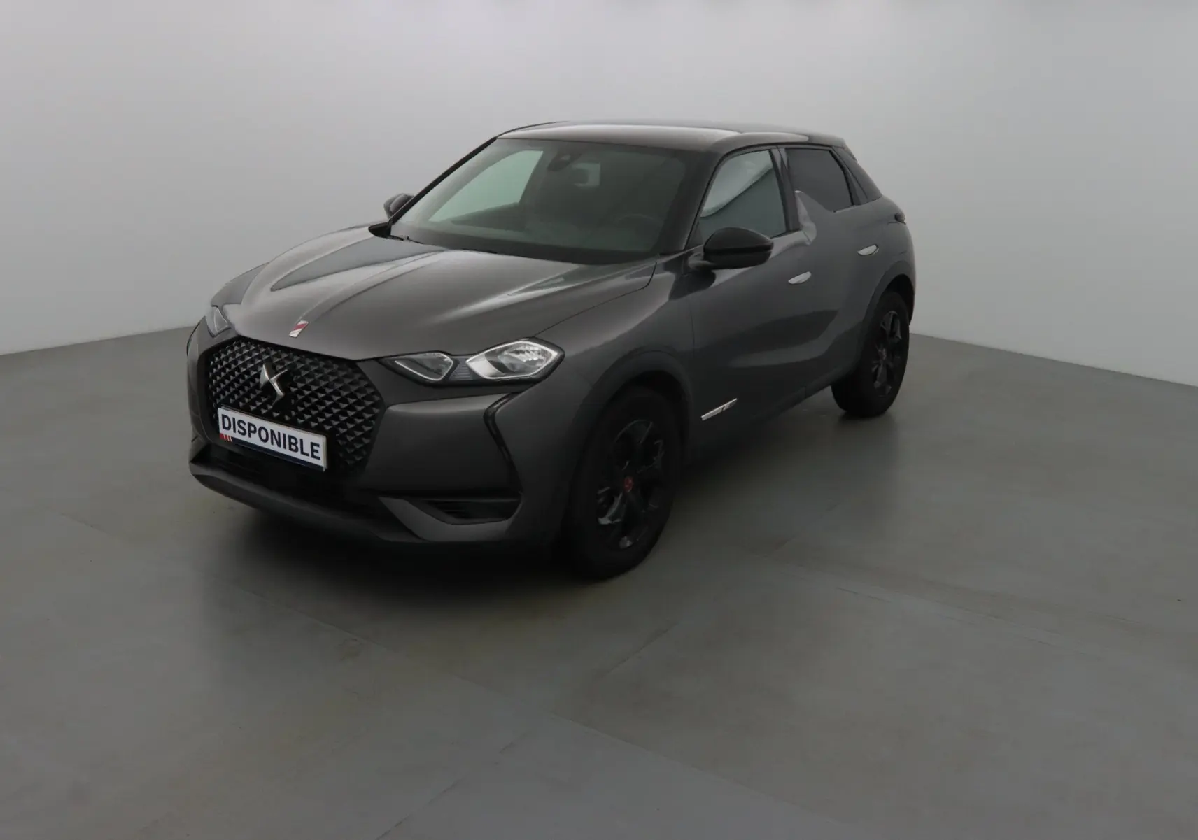 DS3 Crossback gris platinium métal vu en 3/4 avant droit, avec calandre noire et jantes foncées.