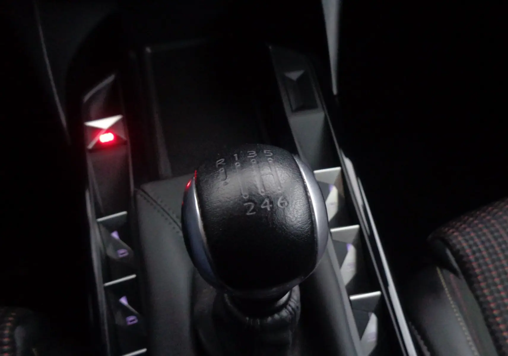 Le levier de vitesses manuel noir de la DS3 Crossback gris platinium, vu en gros plan depuis l'intérieur.