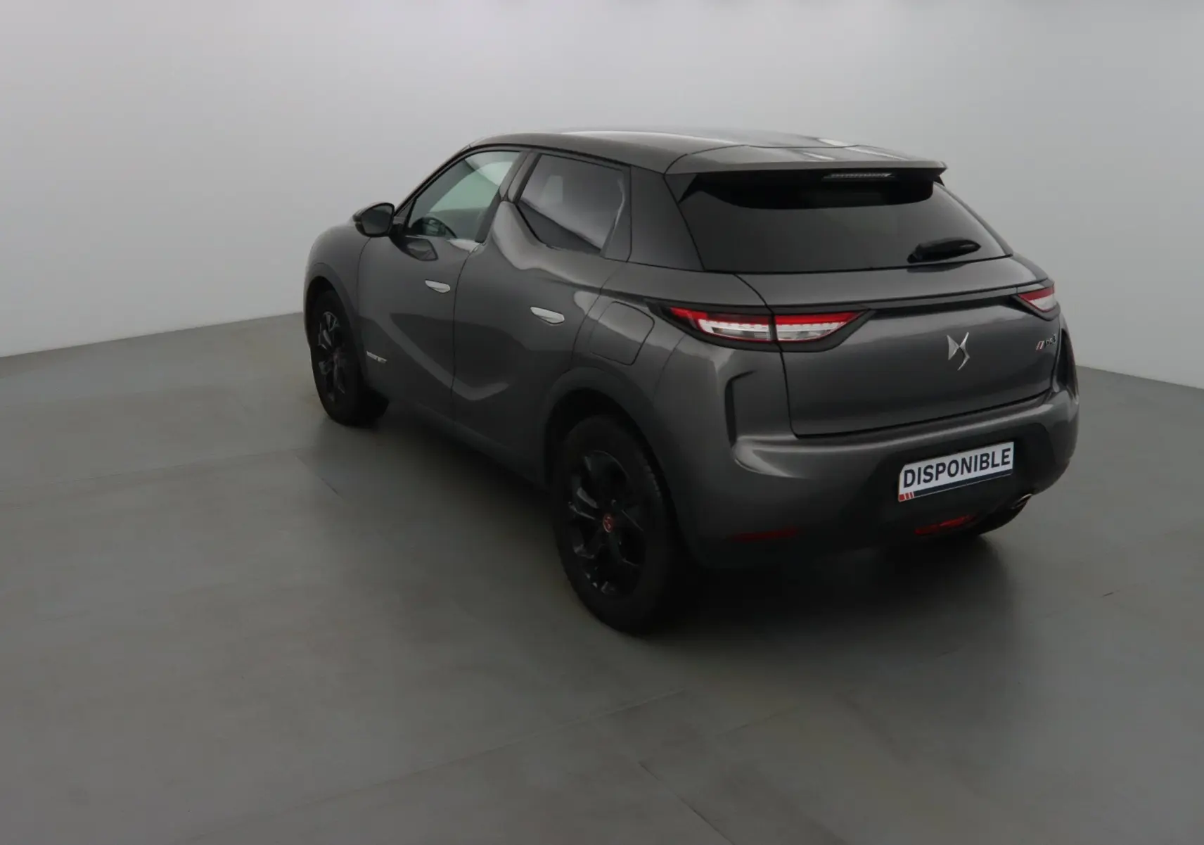DS3 Crossback gris platinium métal vu en 3/4 arrière droit, avec feux arrière LED et jantes noires.