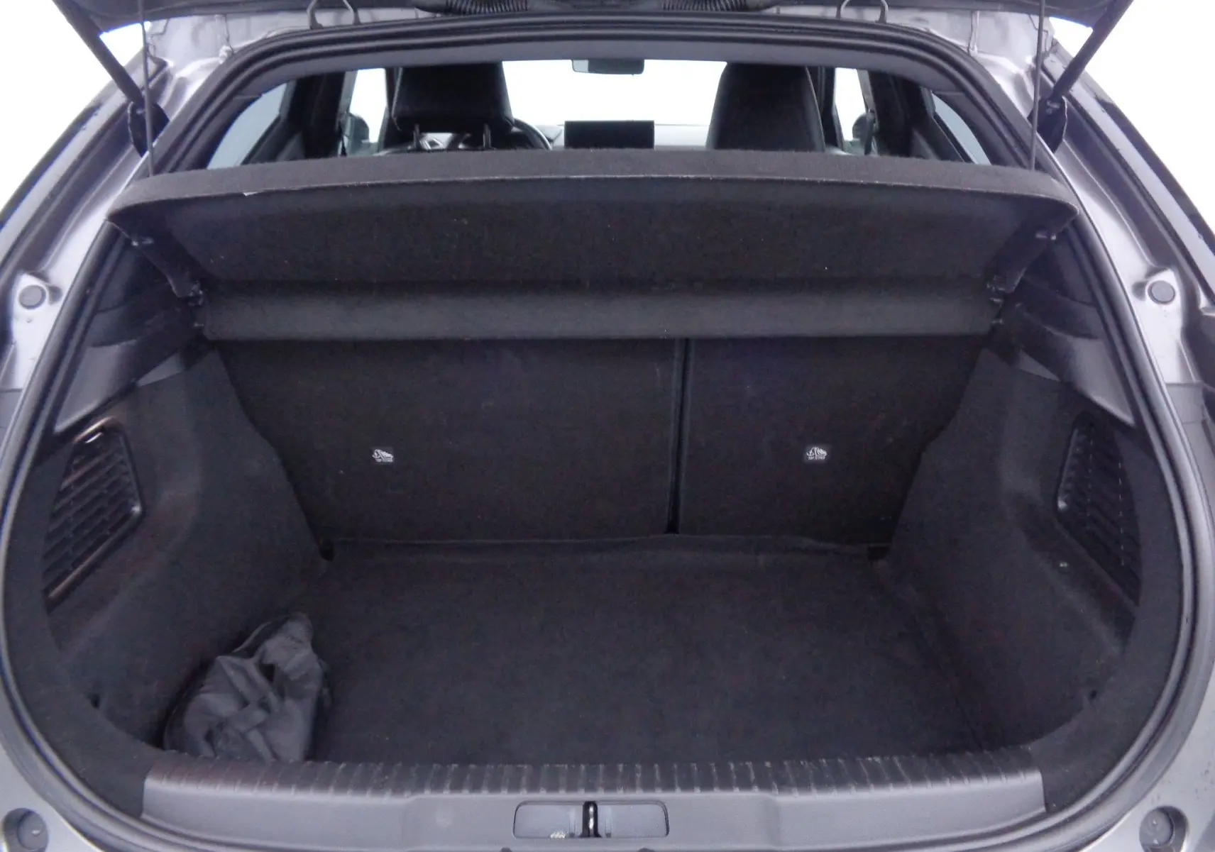 Vue arrière du coffre ouvert d'une DS3 Crossback gris platinium métal, montrant l'espace de chargement et la plage arrière relevée.