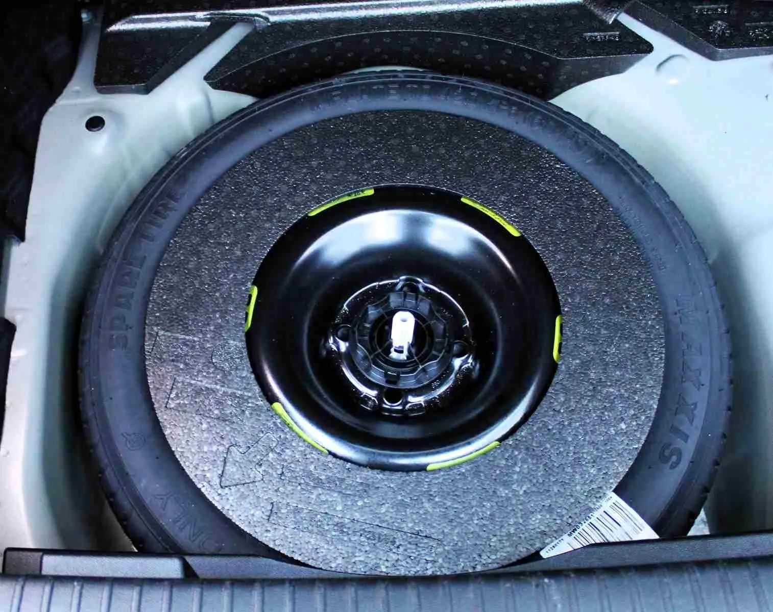 Gros plan sur la roue de secours noire logée dans le coffre, entourée d'un espace gris clair du DS3 Crossback.