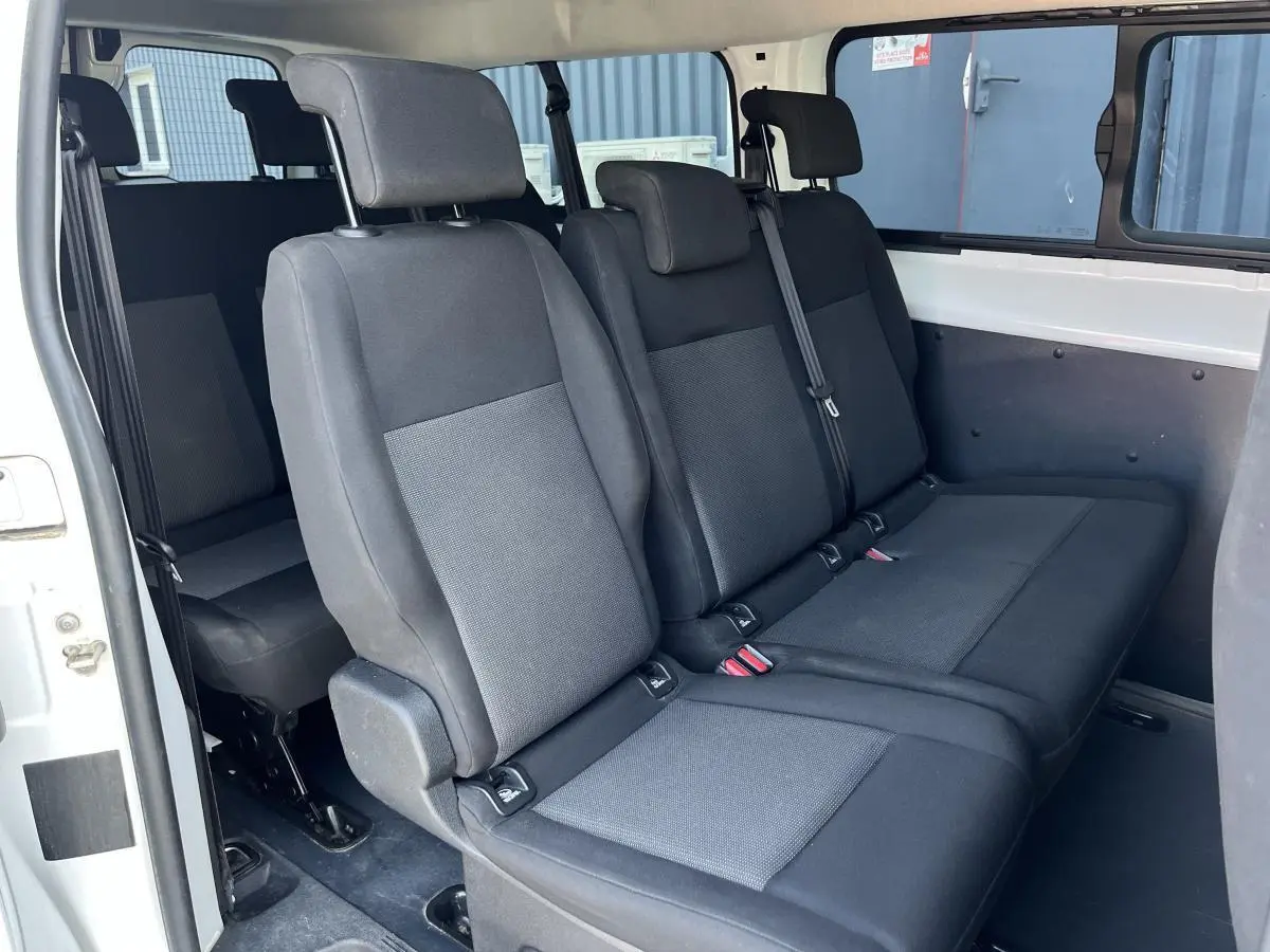 Vue intérieure côté droit sur les sièges tissu gris clair du Toyota Proace Fourgon blanc version 9 places.