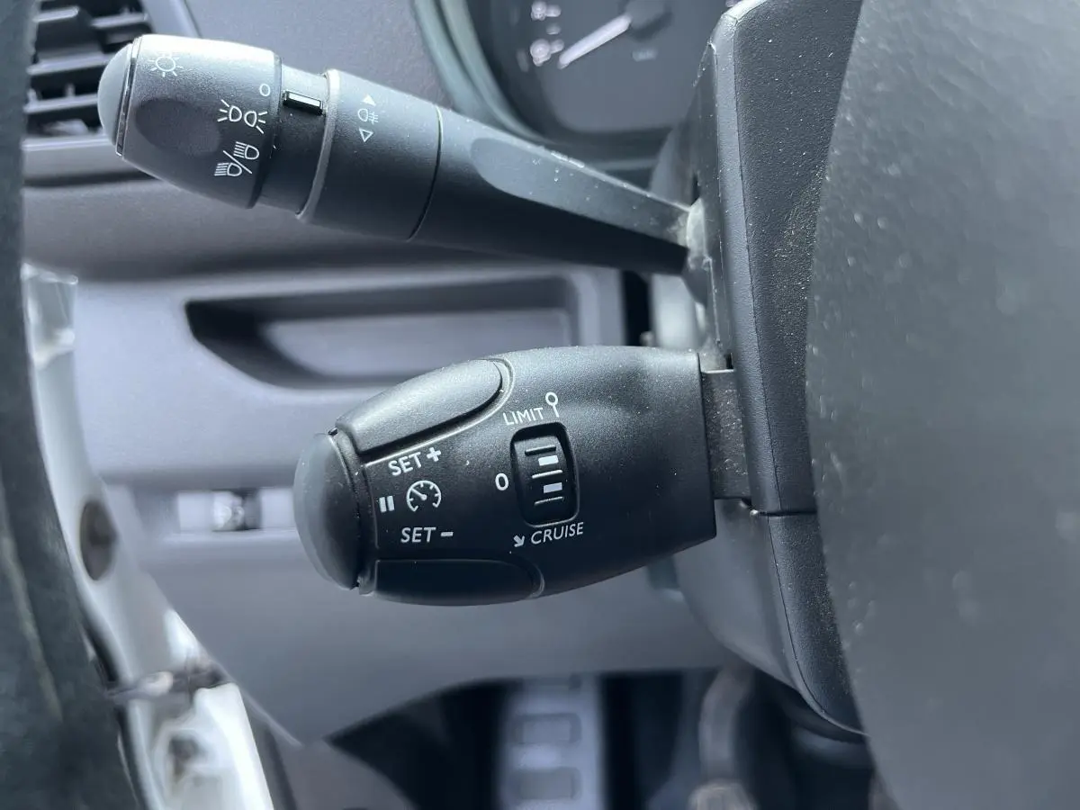 Gros plan sur la commande de régulateur de vitesse du Toyota Proace Fourgon 2021, intérieur gris.