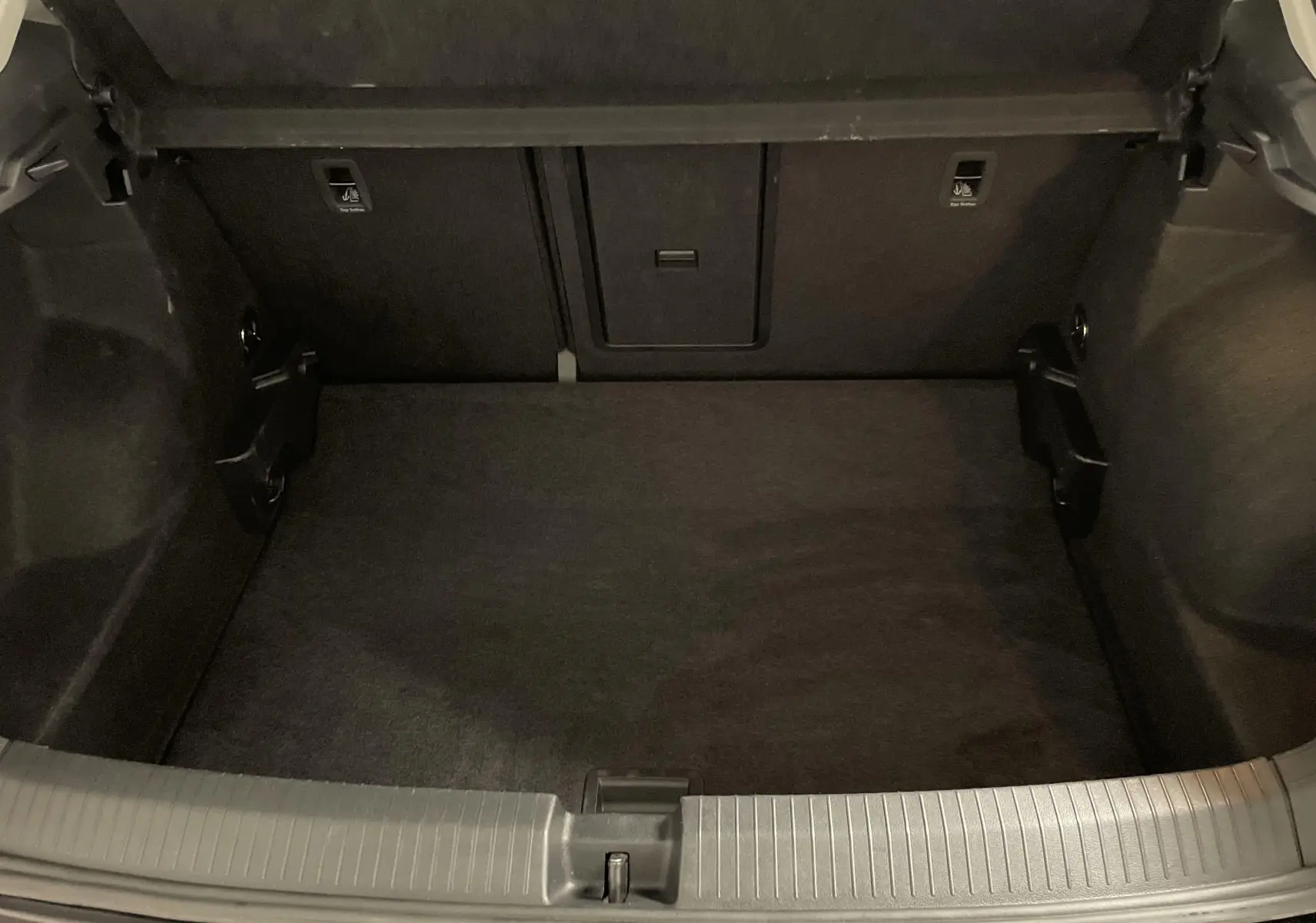 Coffre ouvert du Volkswagen T-Roc noir intense nacré, montrant l'espace de chargement intérieur vide et propre.