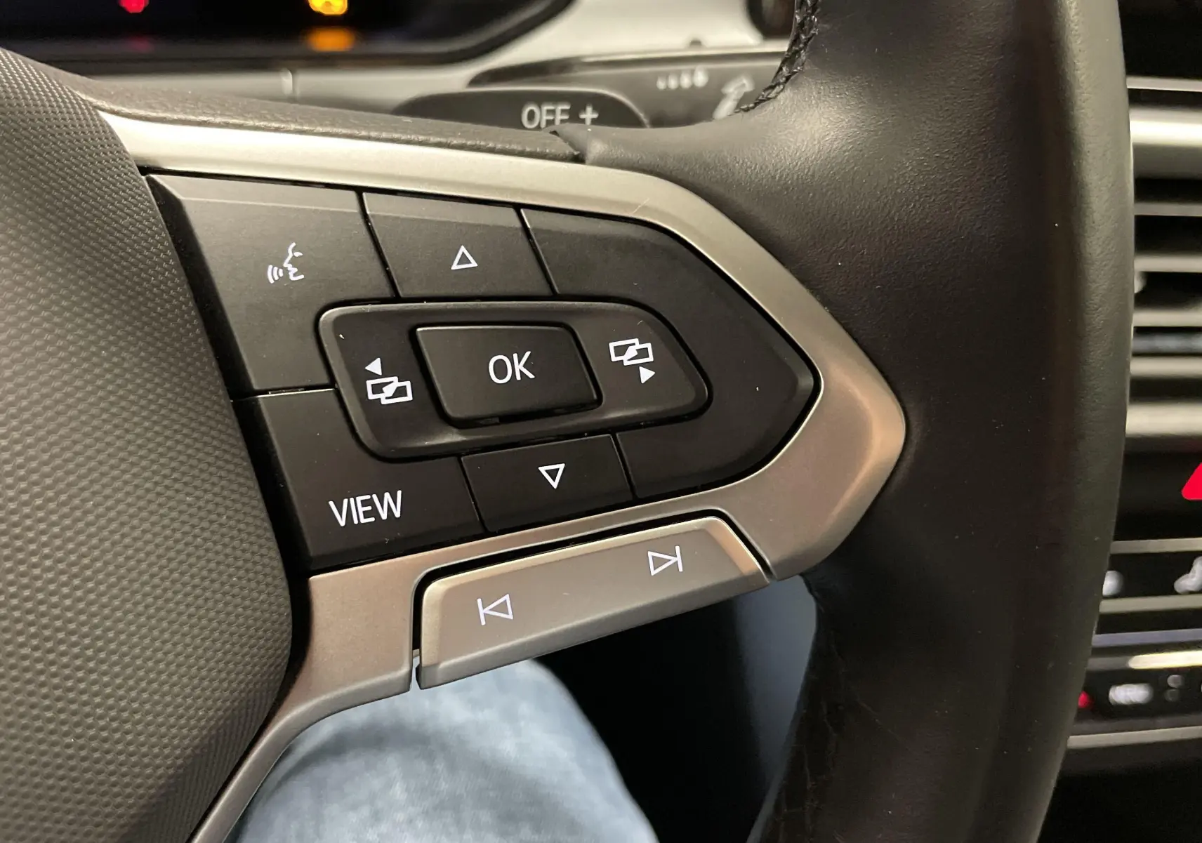 Gros plan sur les commandes multifonctions à droite du volant noir du Volkswagen T-Roc 2024, finition Life Camera.