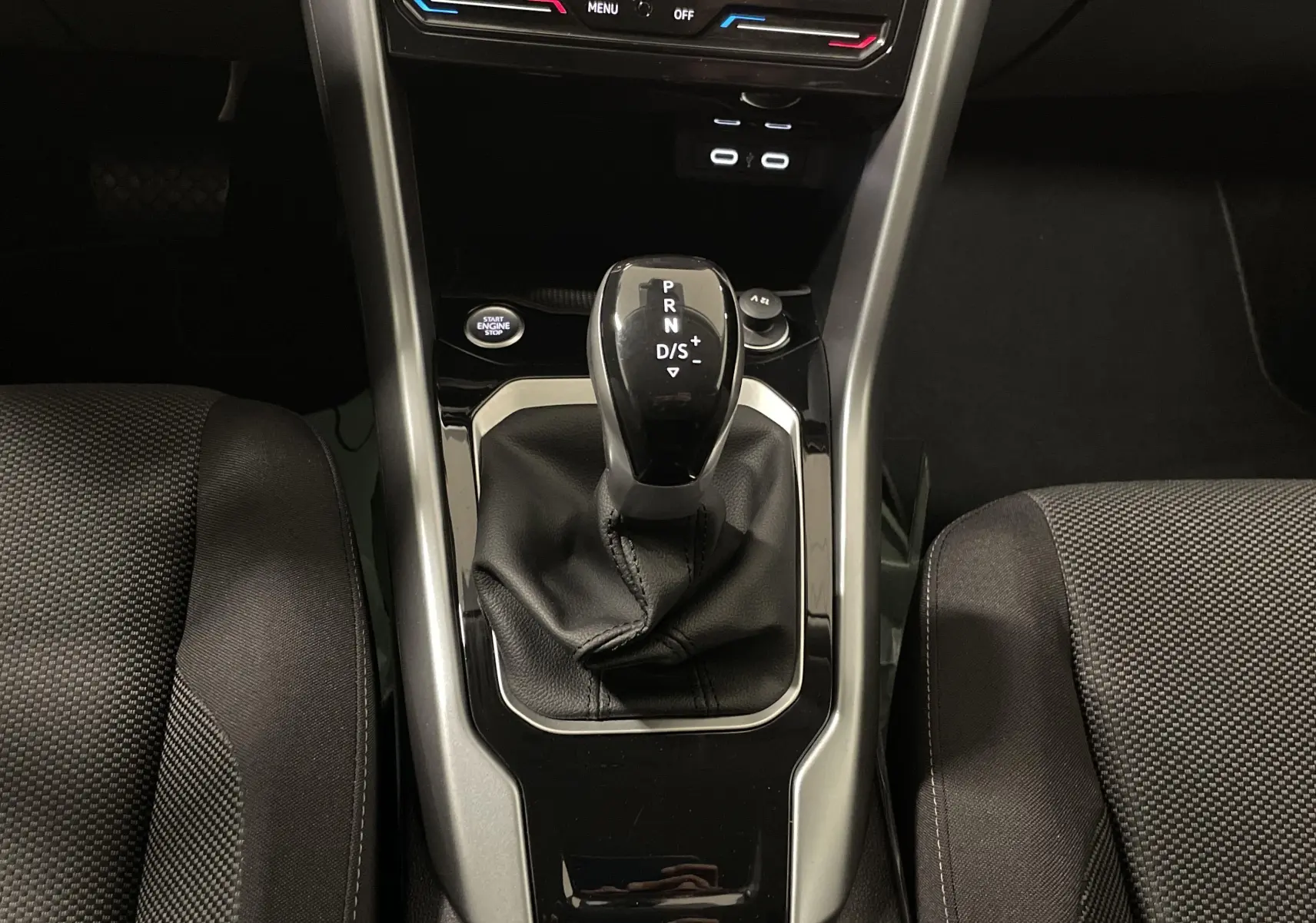 Le levier de vitesse automatique noir du Volkswagen T-Roc 2024, vu de dessus entre les sièges avant.